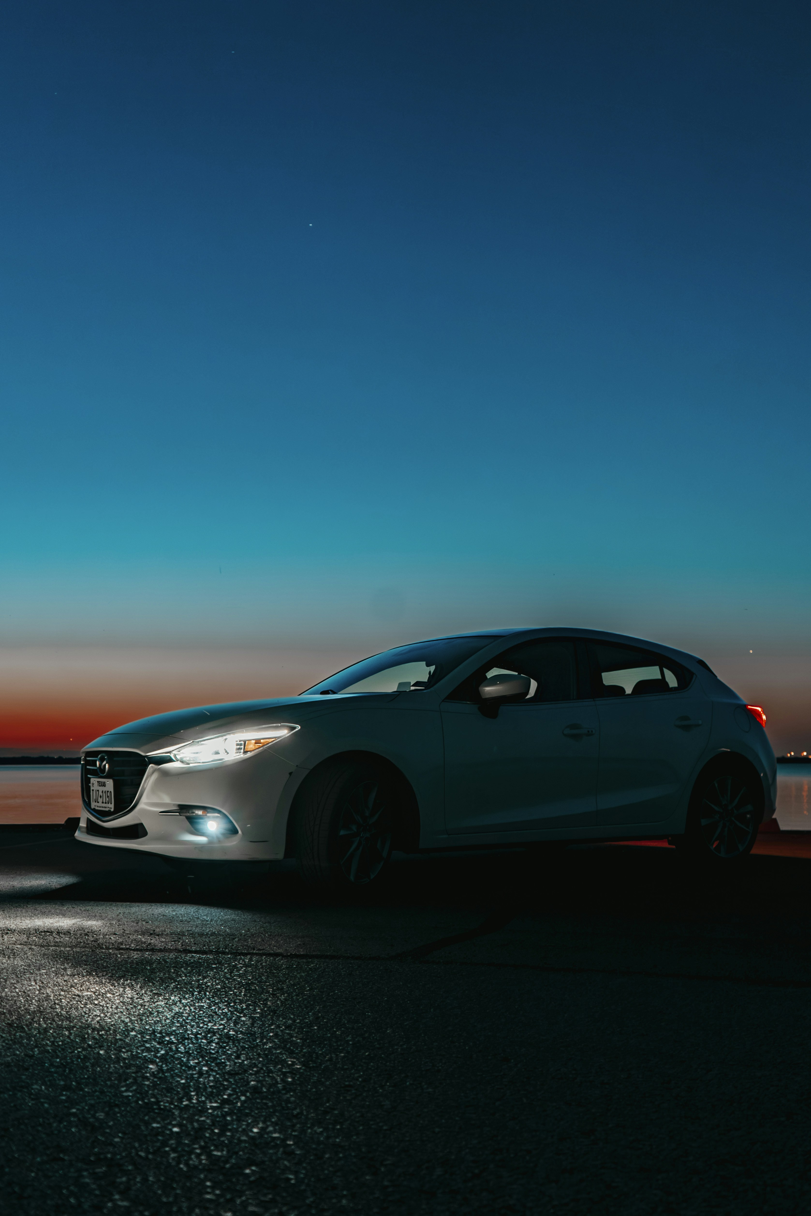 A car parked on the side of the road at night