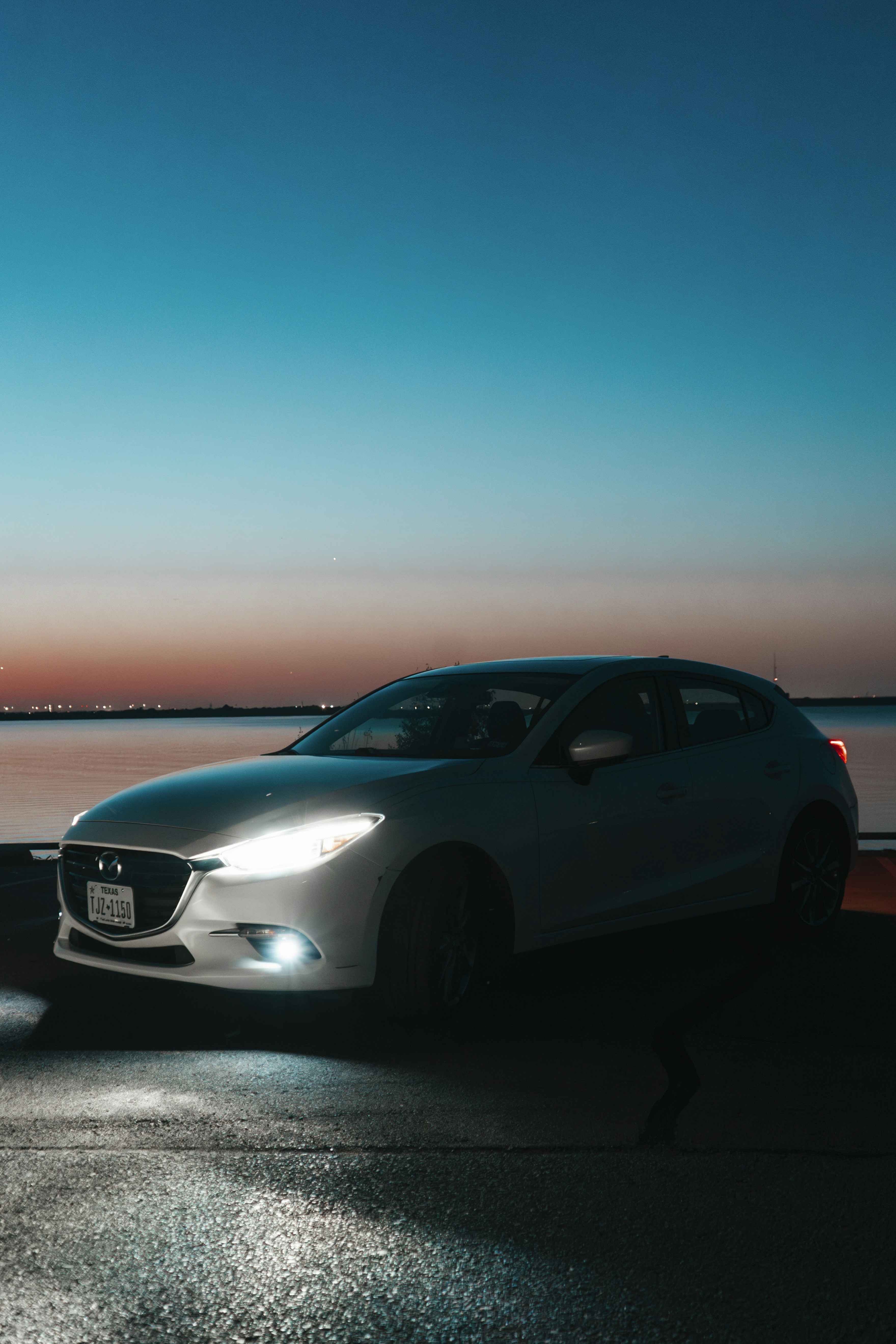 A car parked on the side of a road near a body of water