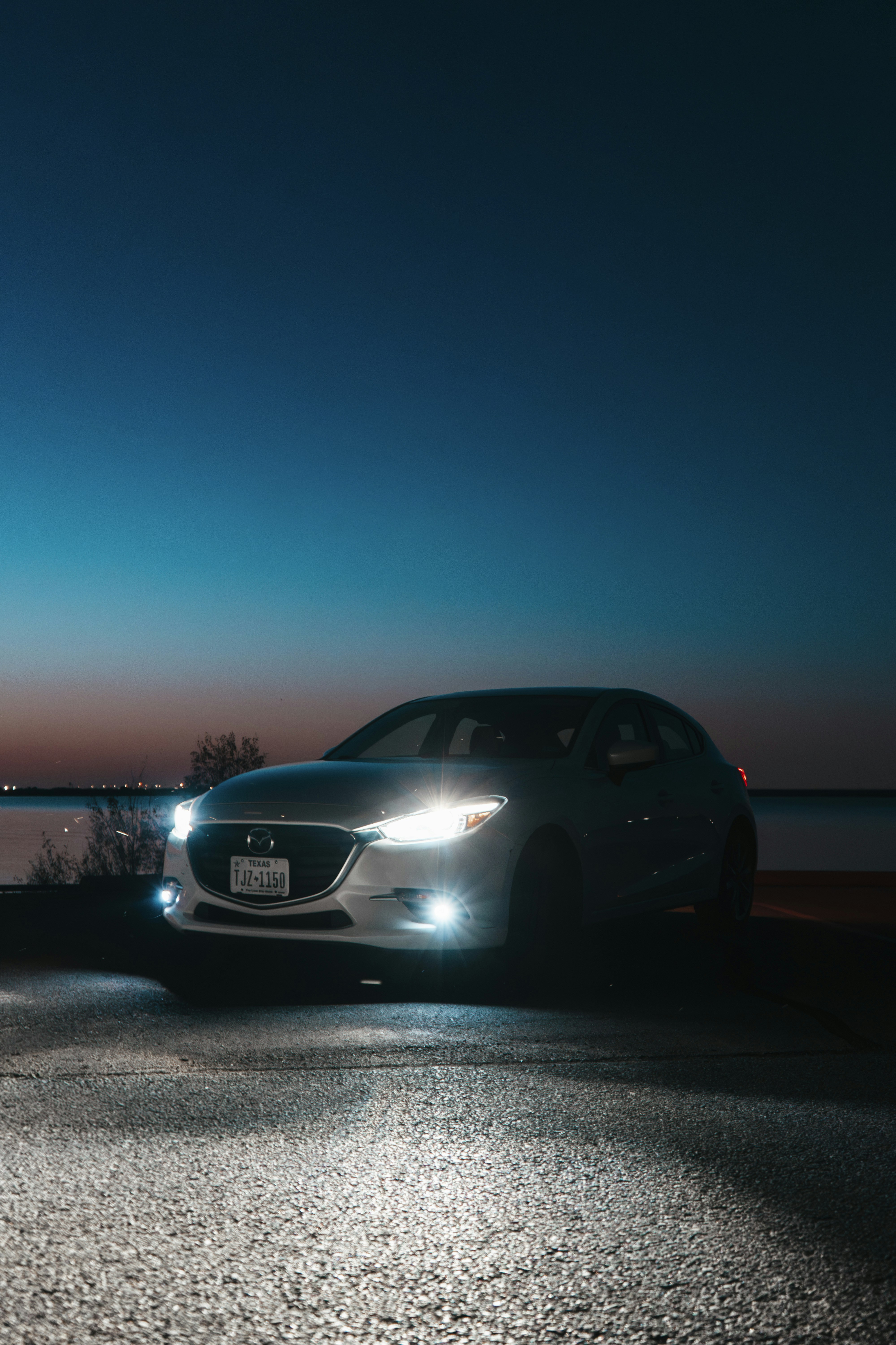 A car parked on the side of the road at night