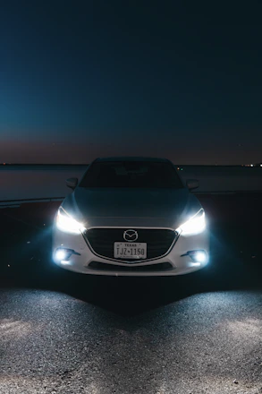 A white car parked on the side of a road at night
