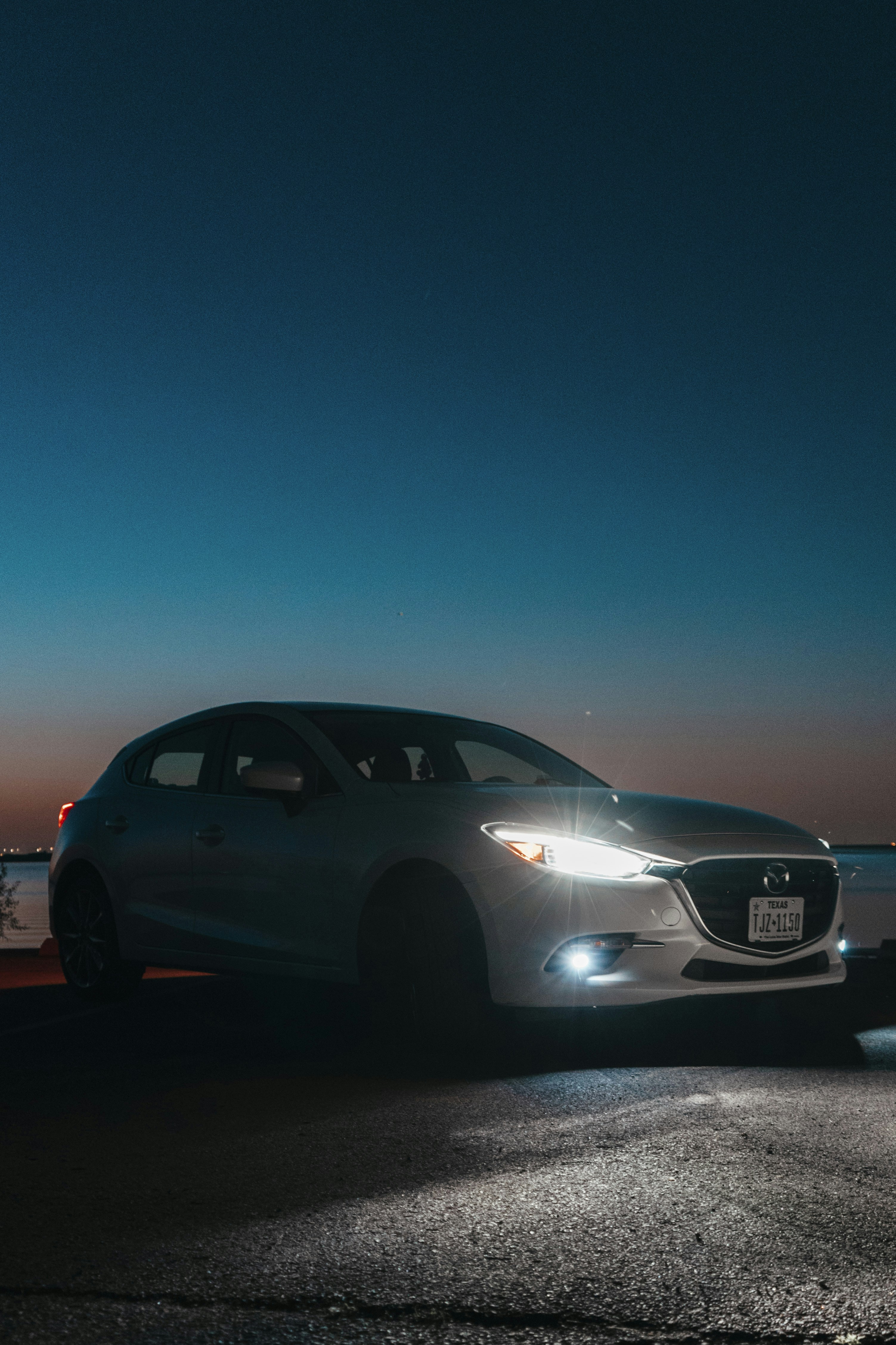 A car parked on the side of the road at night