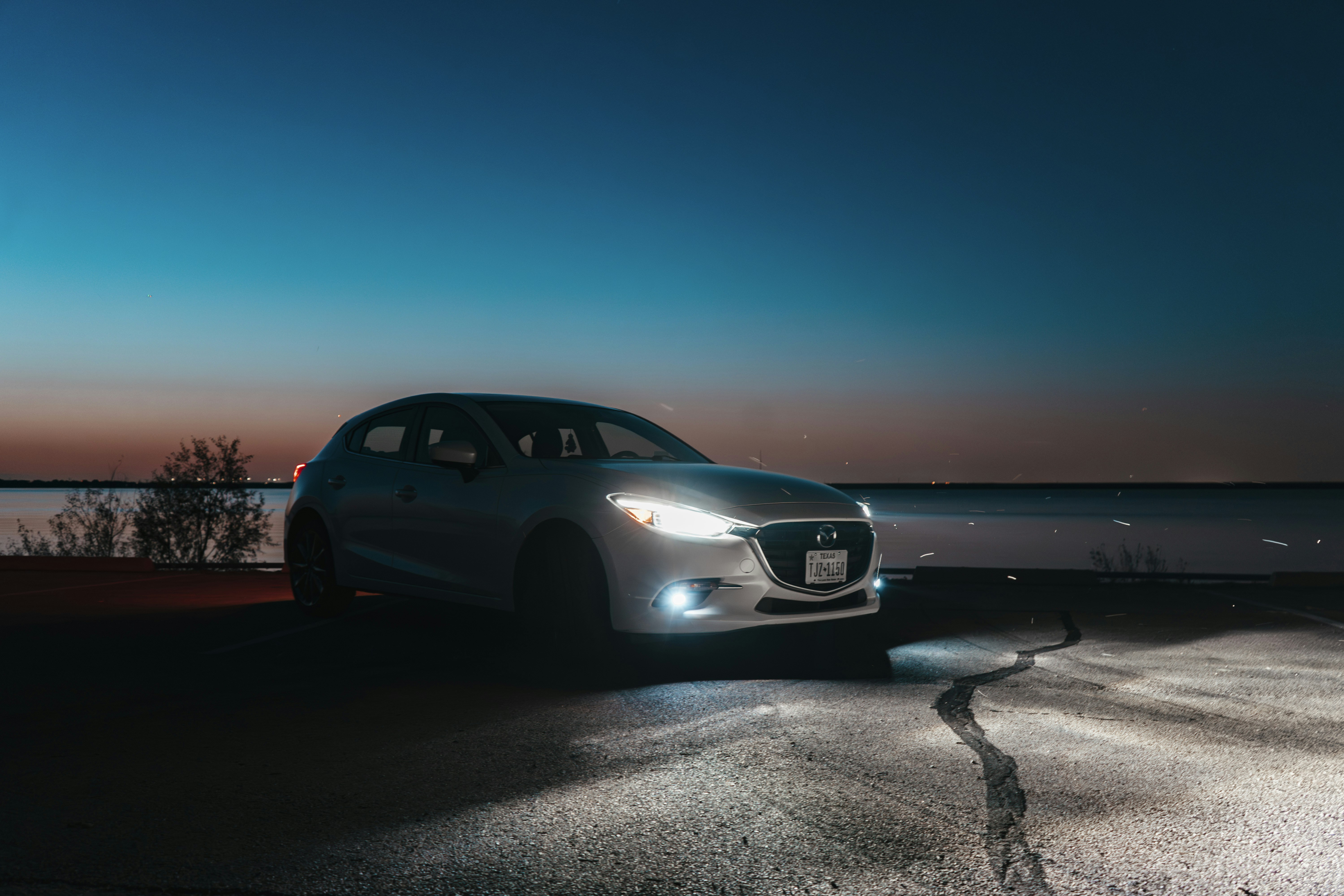 A car parked on the side of the road at night