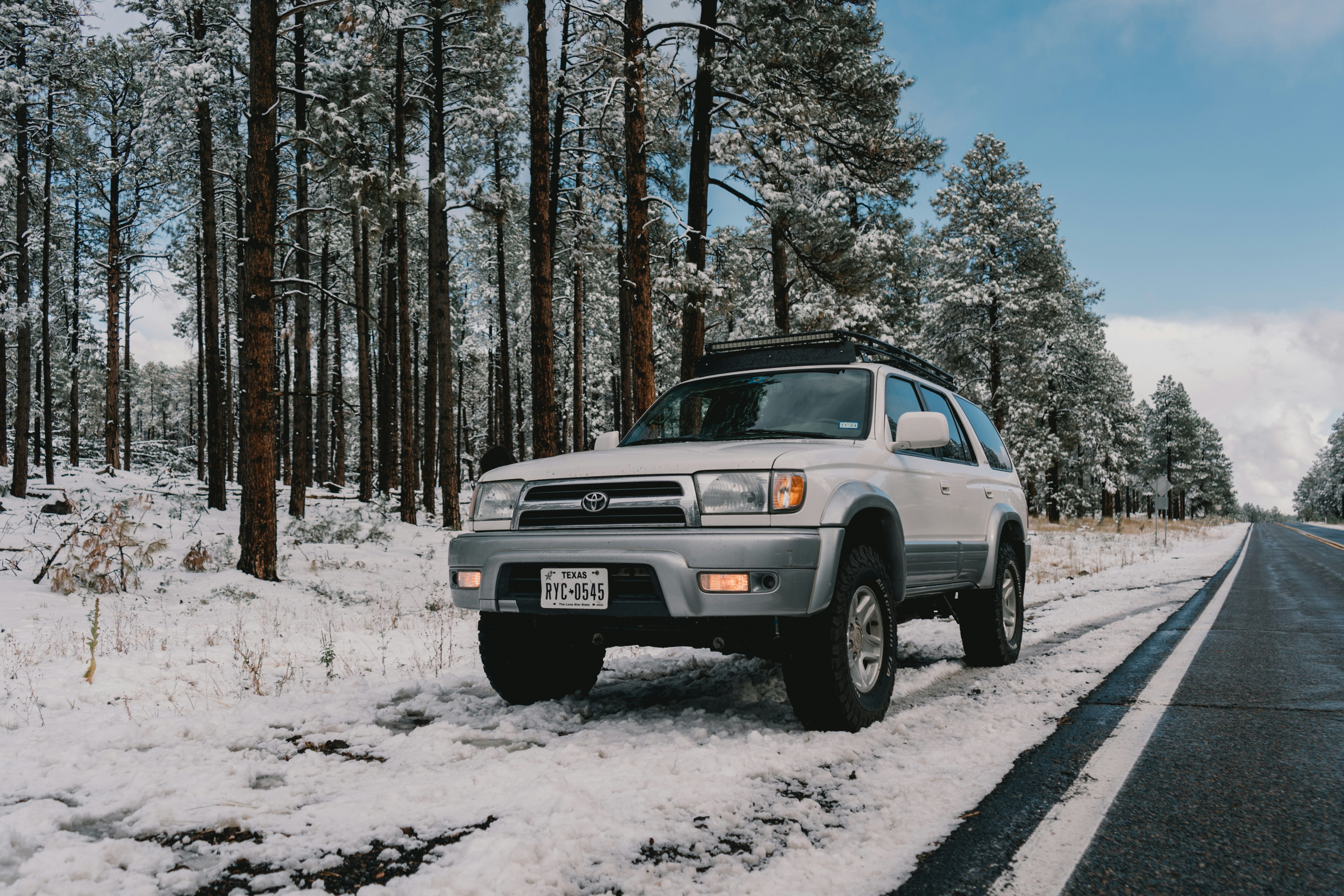 Ein silberner Lastwagen, der über eine schneebedeckte Straße fährt