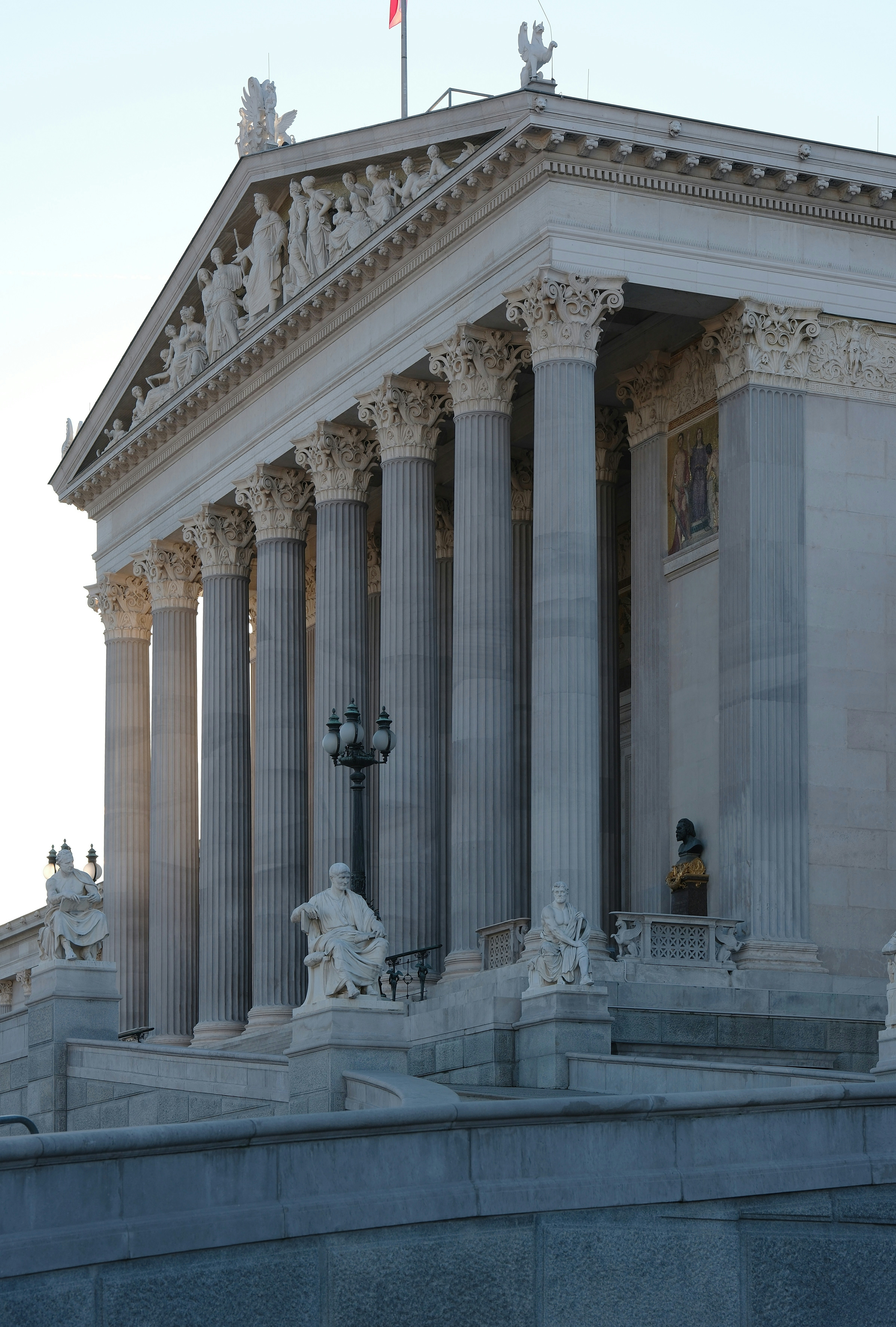 A large building with columns and a flag on top of it
