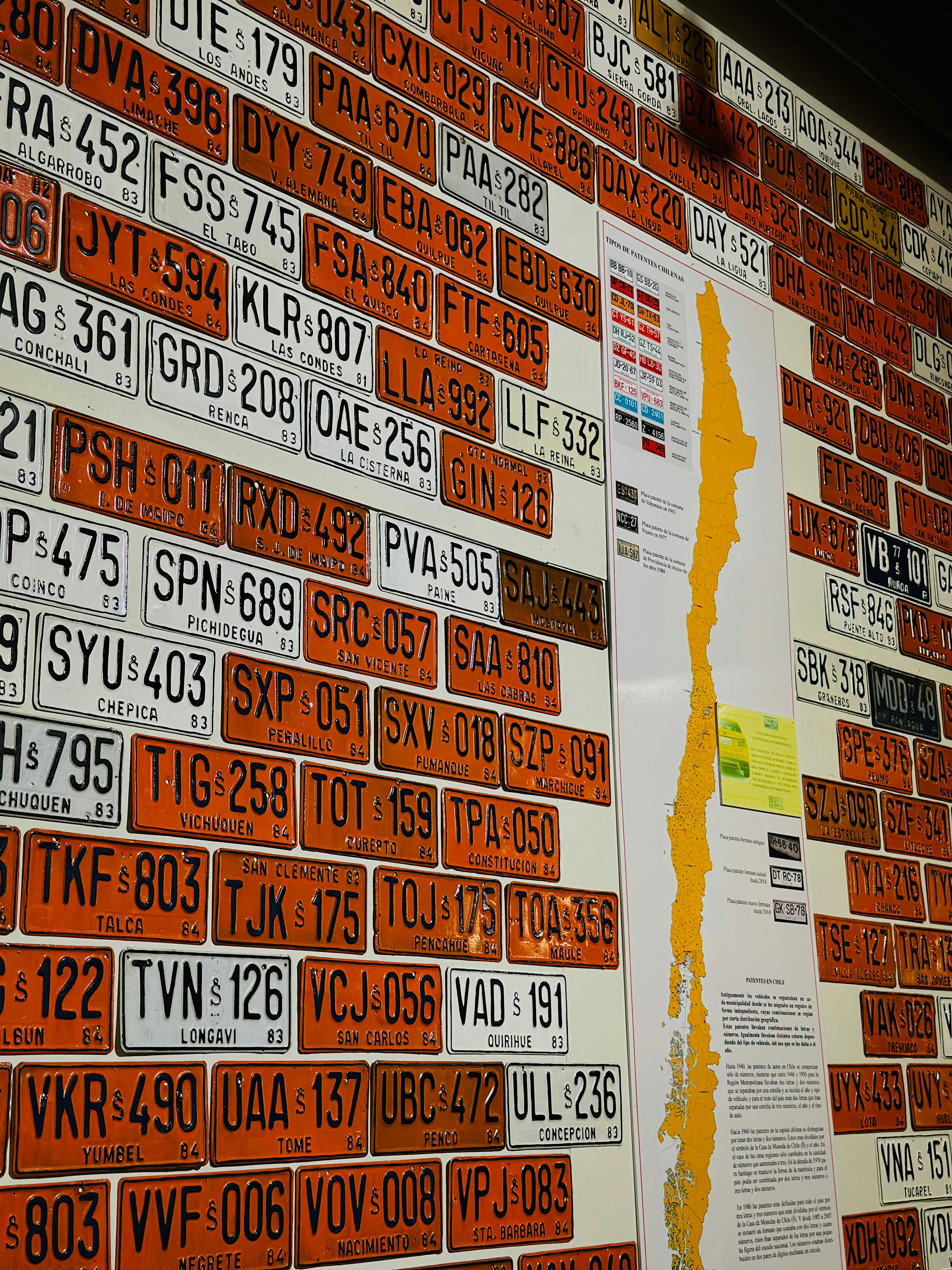 A brick wall with a number of different types of license plates on it
