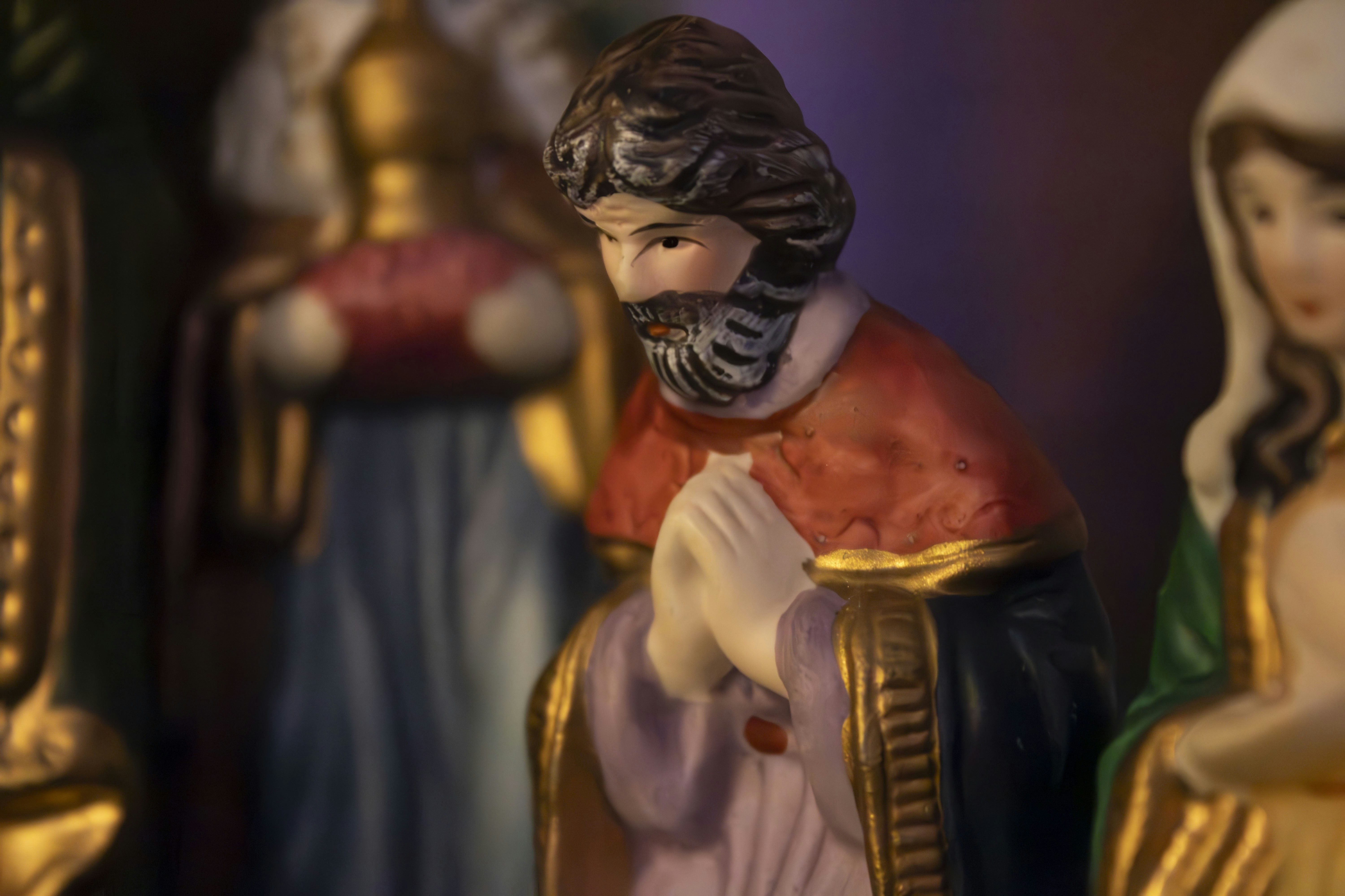 A figurine of a man with a cross and other figurines