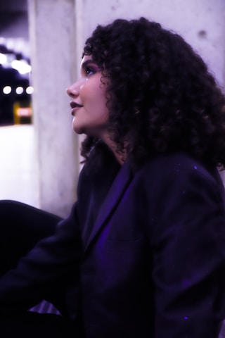 A woman with curly hair sitting on a bench