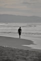 A person walking on a beach near the ocean