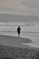 A person walking on a beach near the ocean