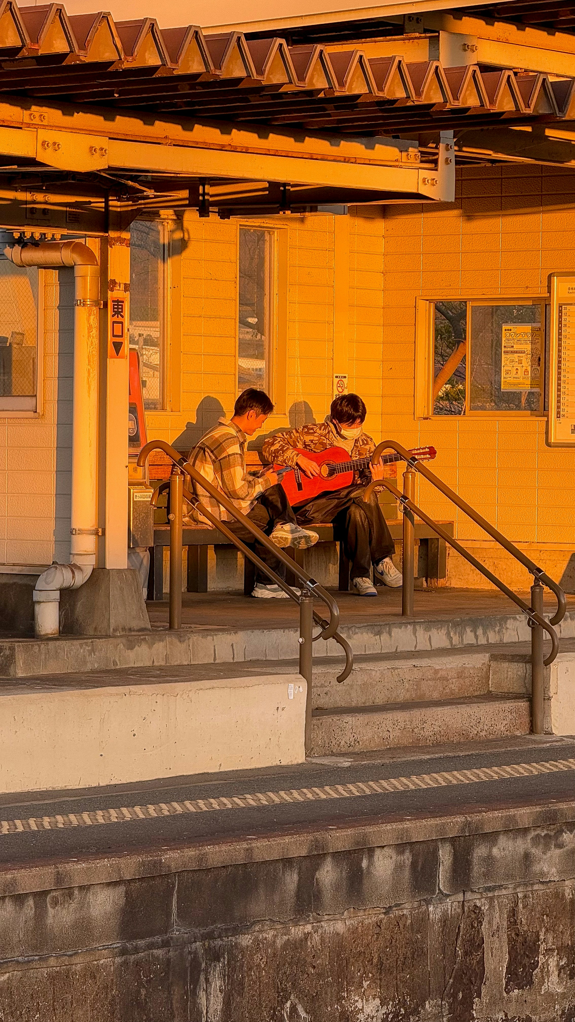 A group of people sitting on a train platform