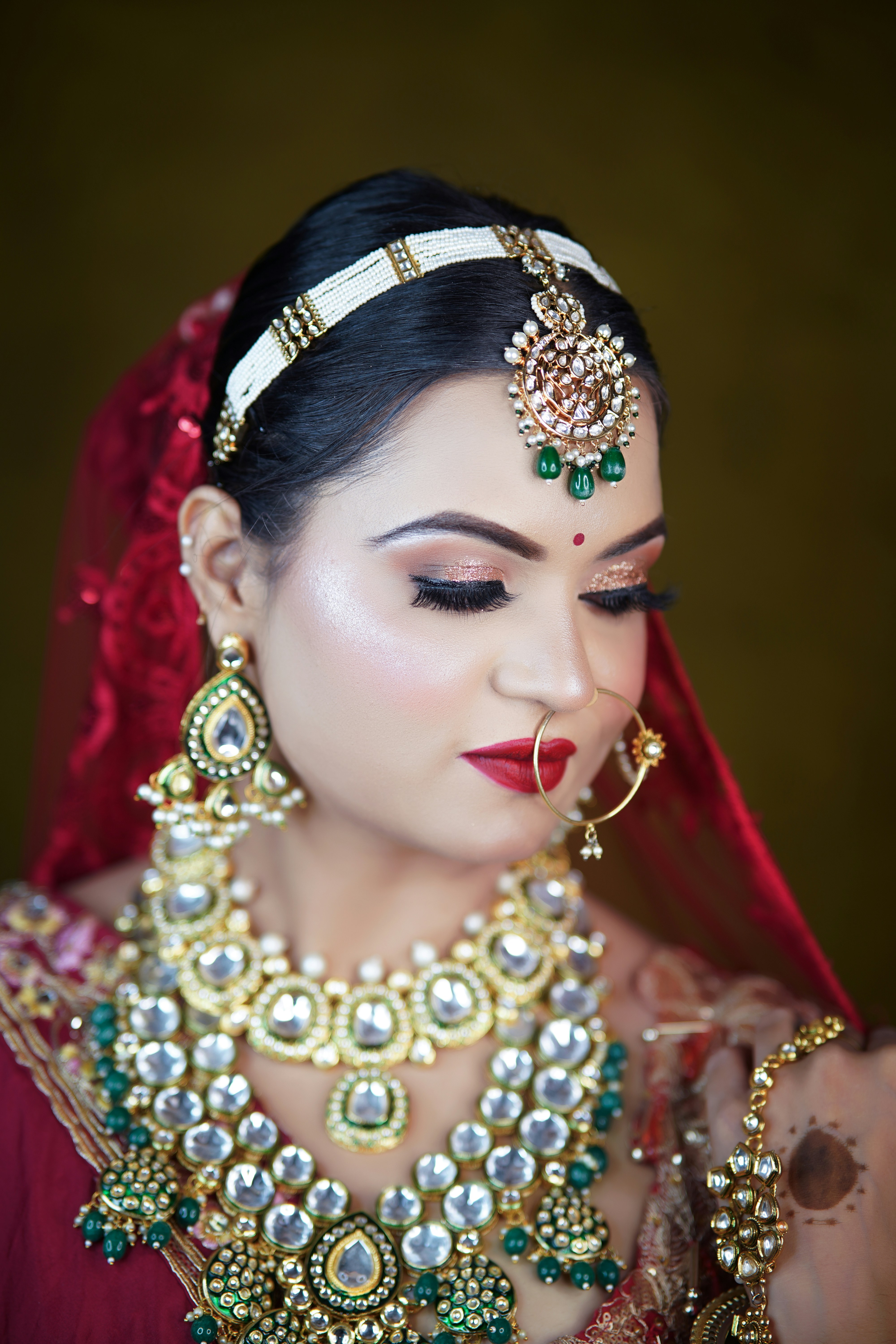 A woman in a red dress with a necklace and earrings