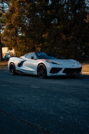 A white sports car parked on the side of the road