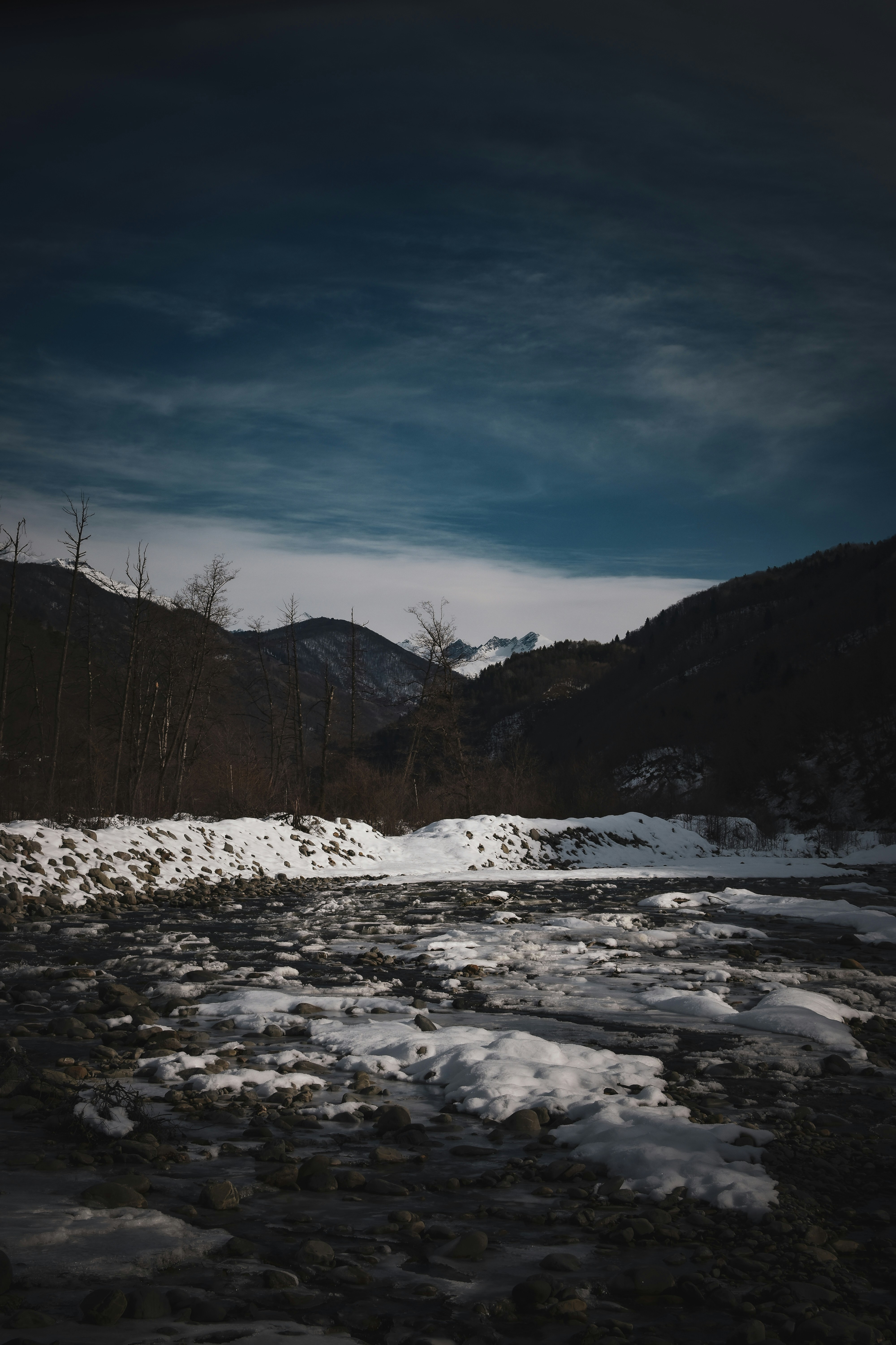 A river running through a forest covered in snow