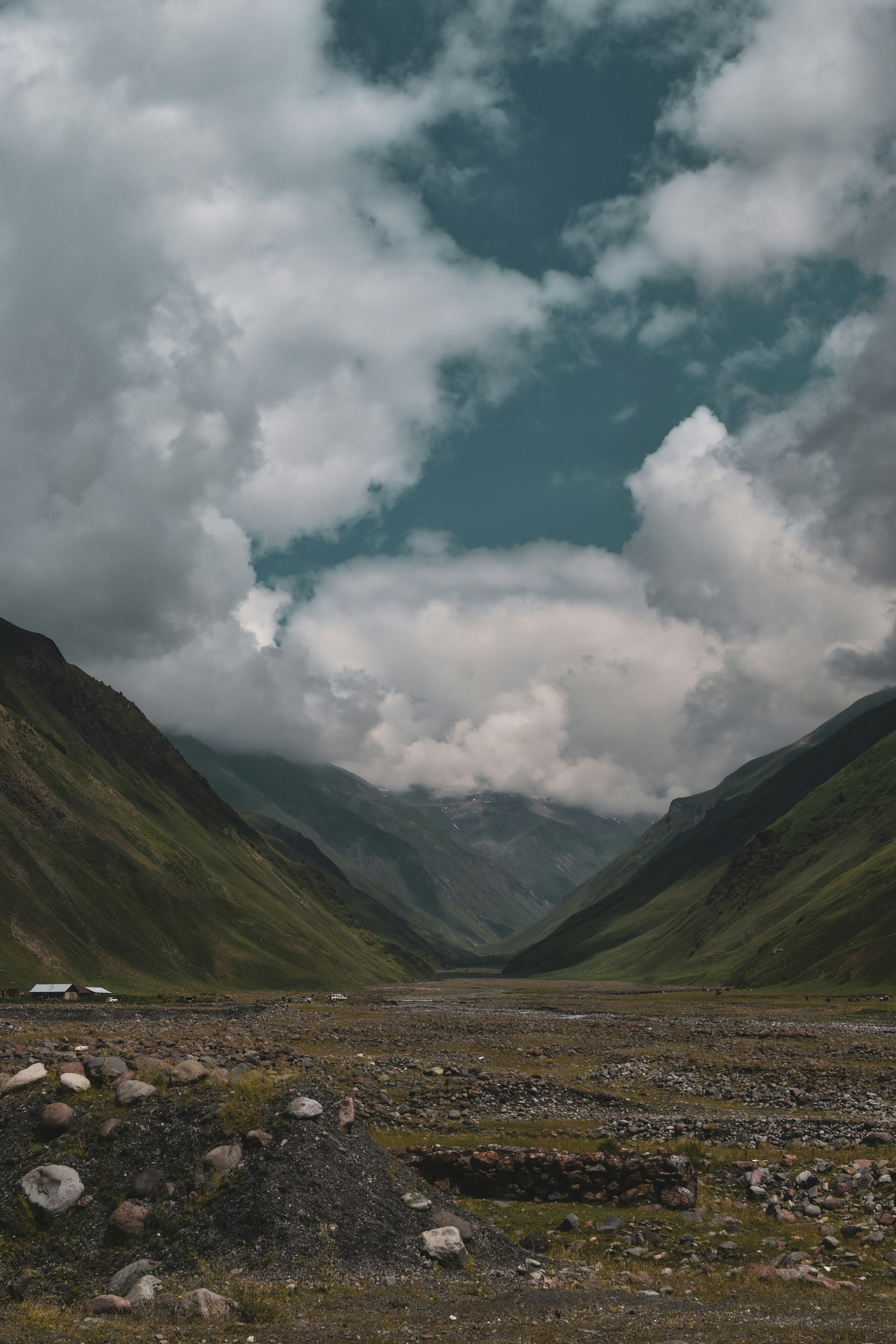 A mountain valley with a cloudy sky in the background