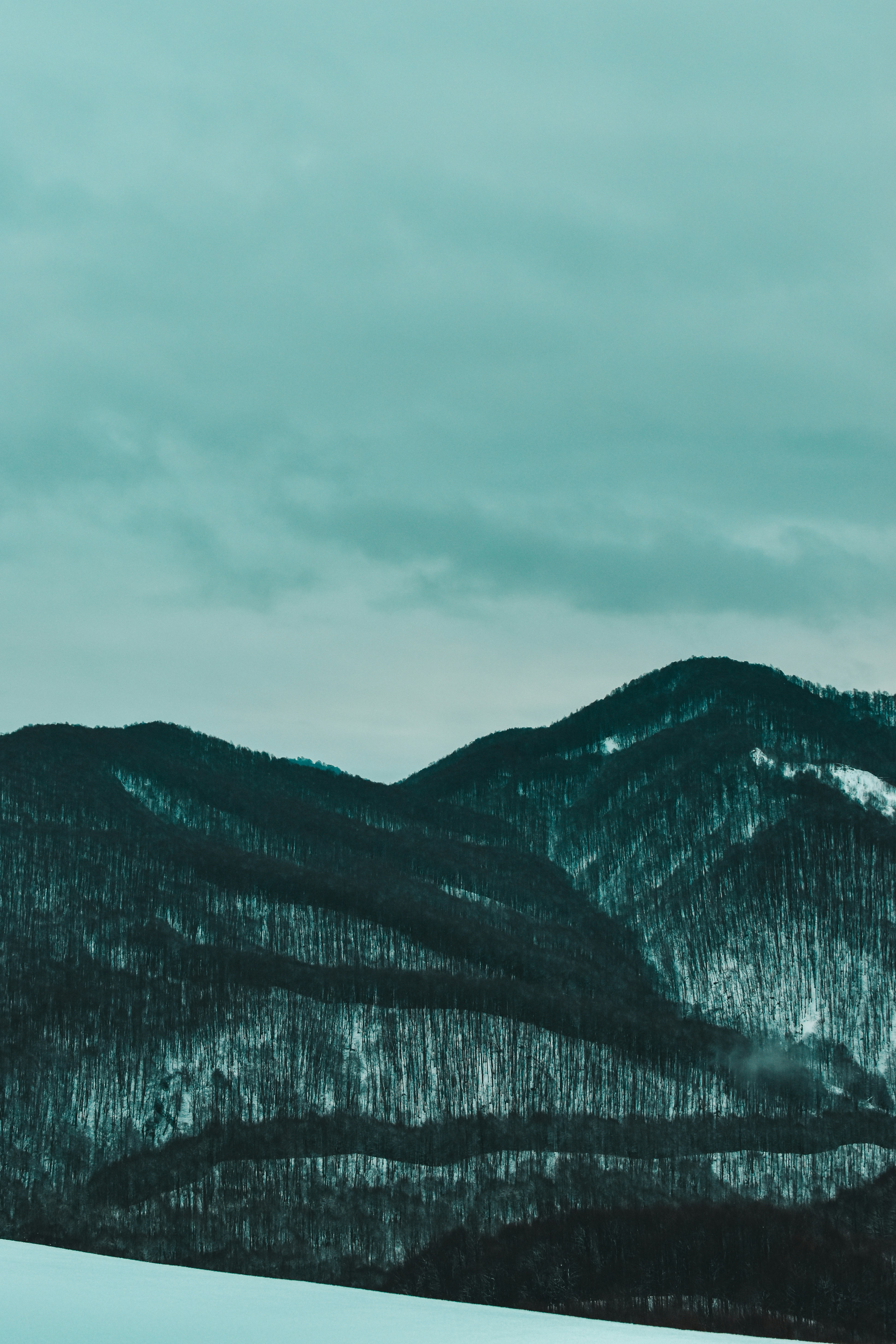 A man riding a snowboard down a snow covered slope