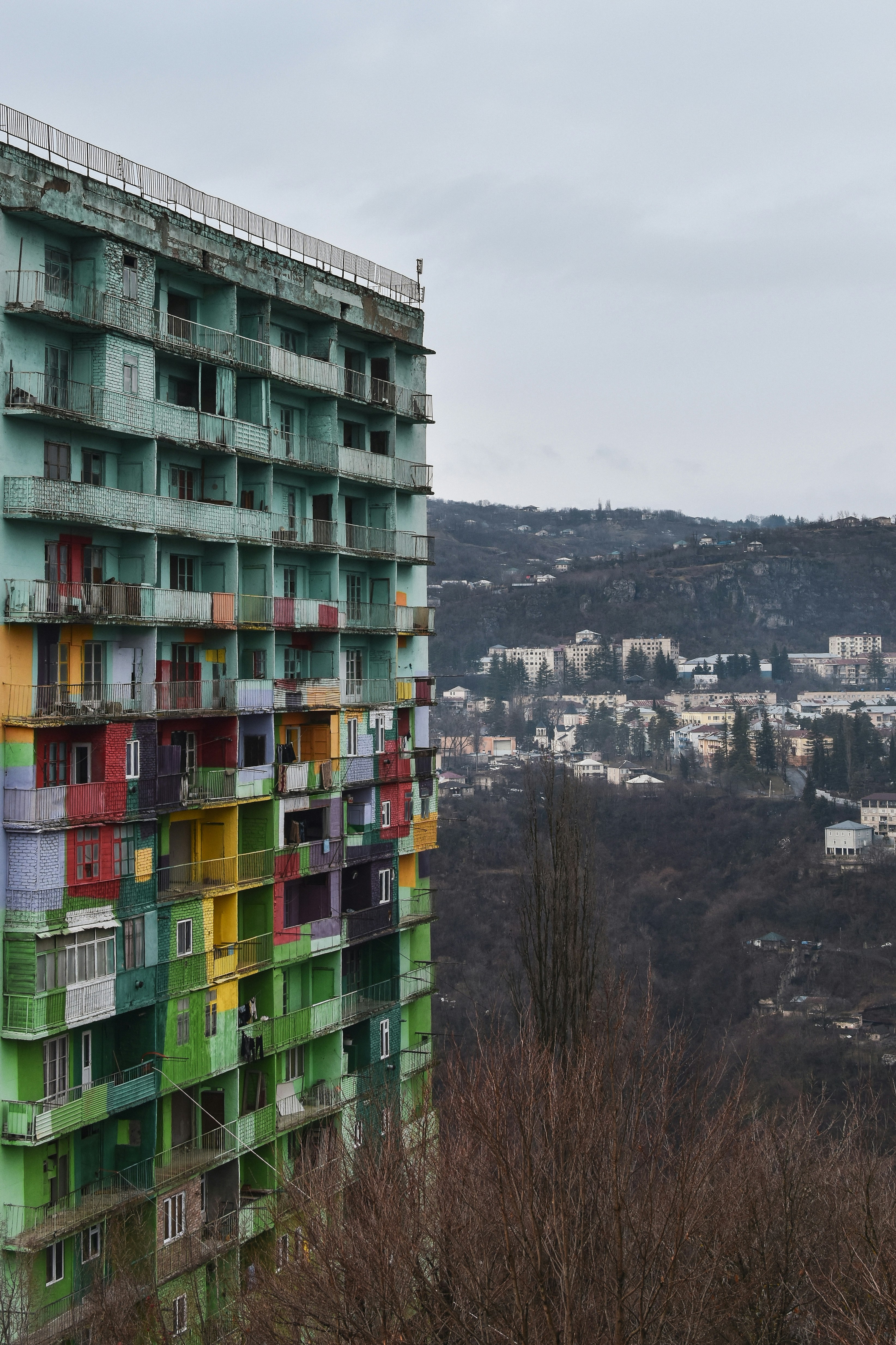 A multicolored building with a view of a city in the background