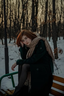 A woman sitting on a bench in the snow