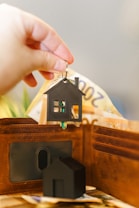 A person putting a house key into a wallet