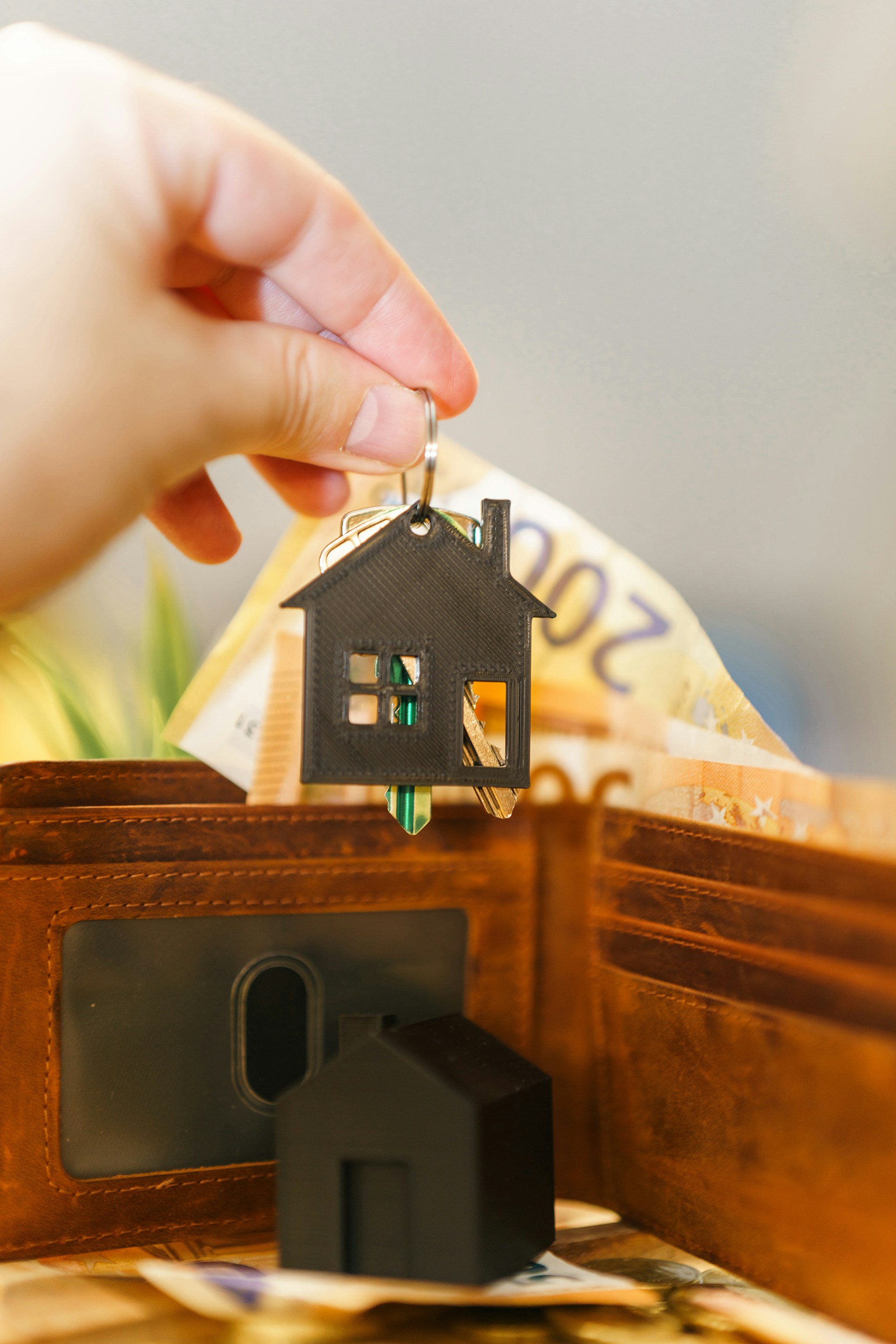 A person putting a house key into a wallet