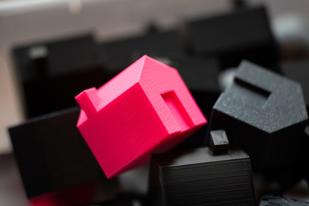 A group of black and pink objects sitting on top of a table, Real estate property selection box with house-shaped blocks