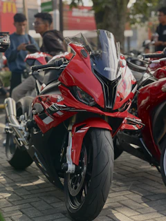 A red motorcycle parked on a brick road