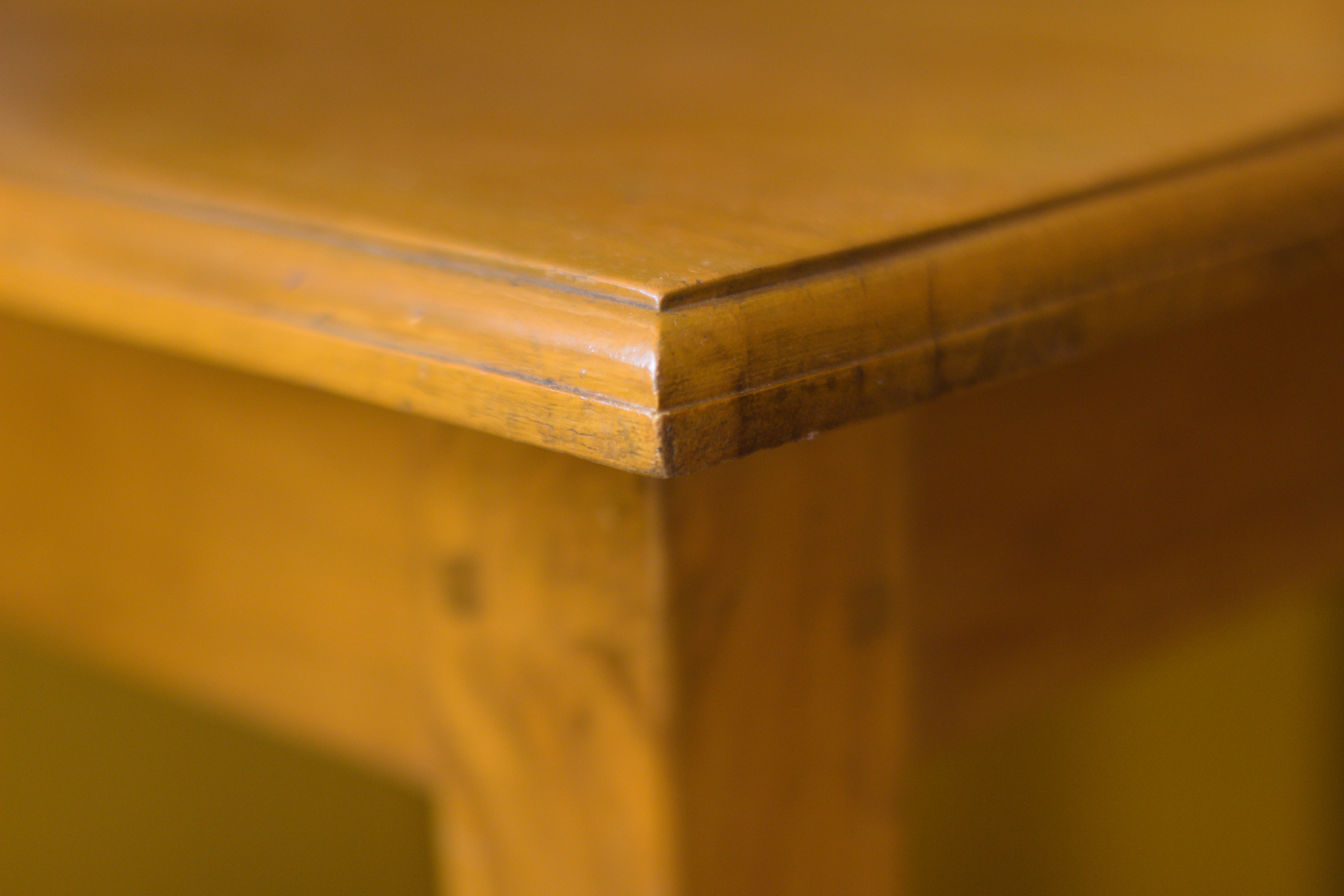 A close-up shot of a wooden table corner showcasing the natural grain and warm tones of the wood