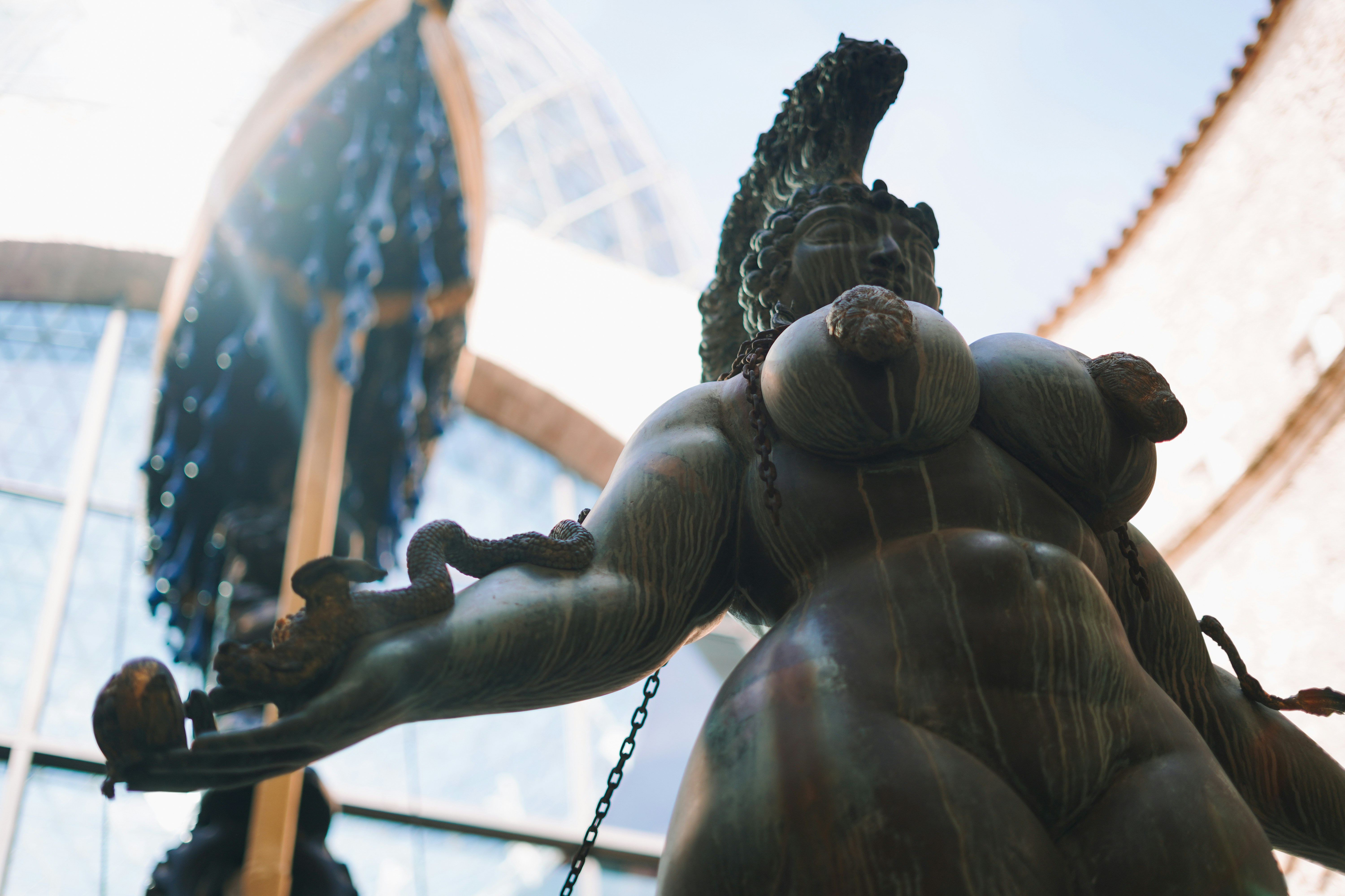 A statue of a man holding a sword in front of a building