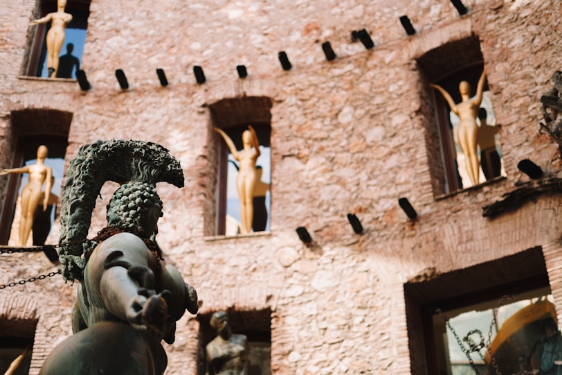 A statue in front of a building with statues on it
