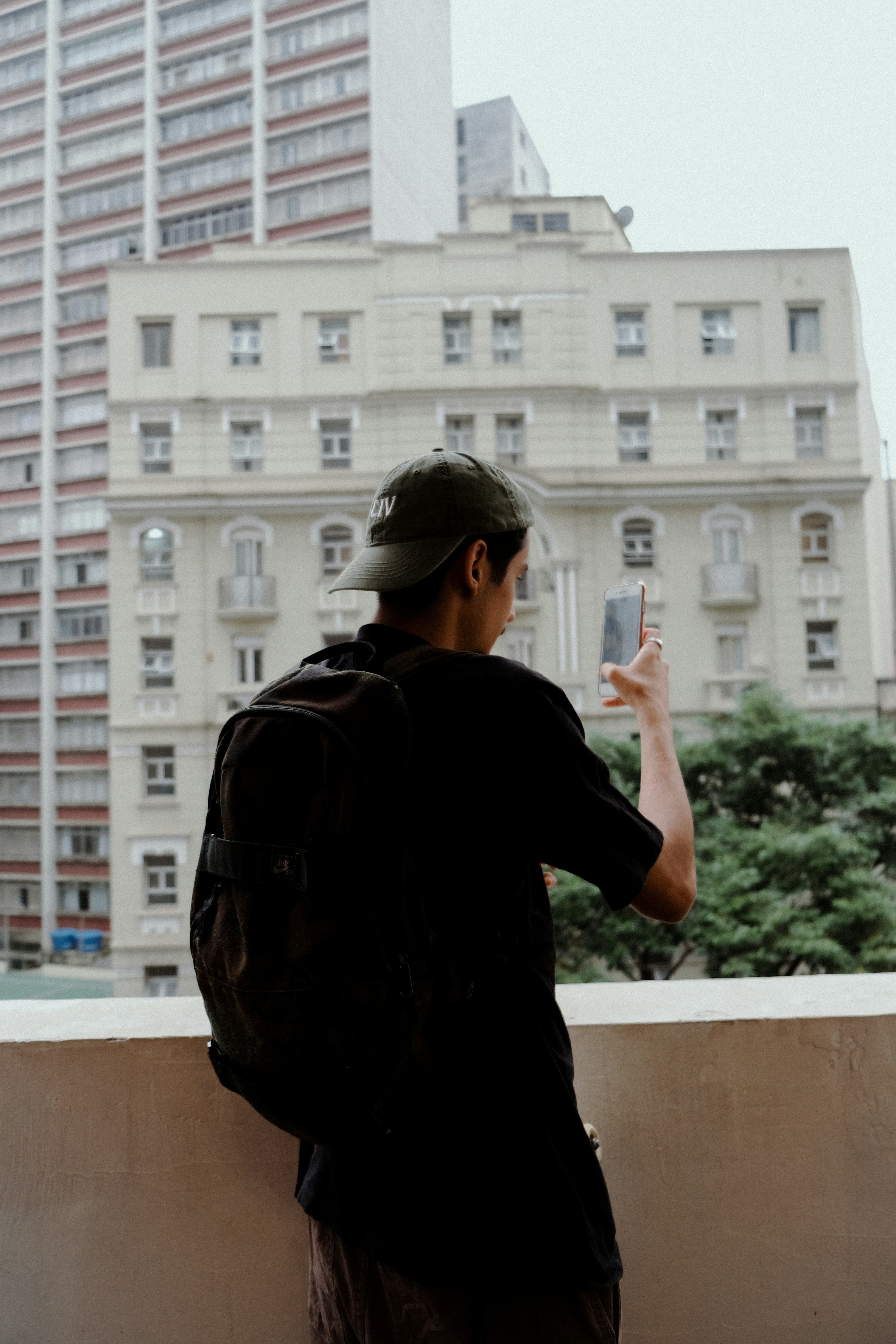 Un homme prend une photo d’un immeuble avec un téléphone portable