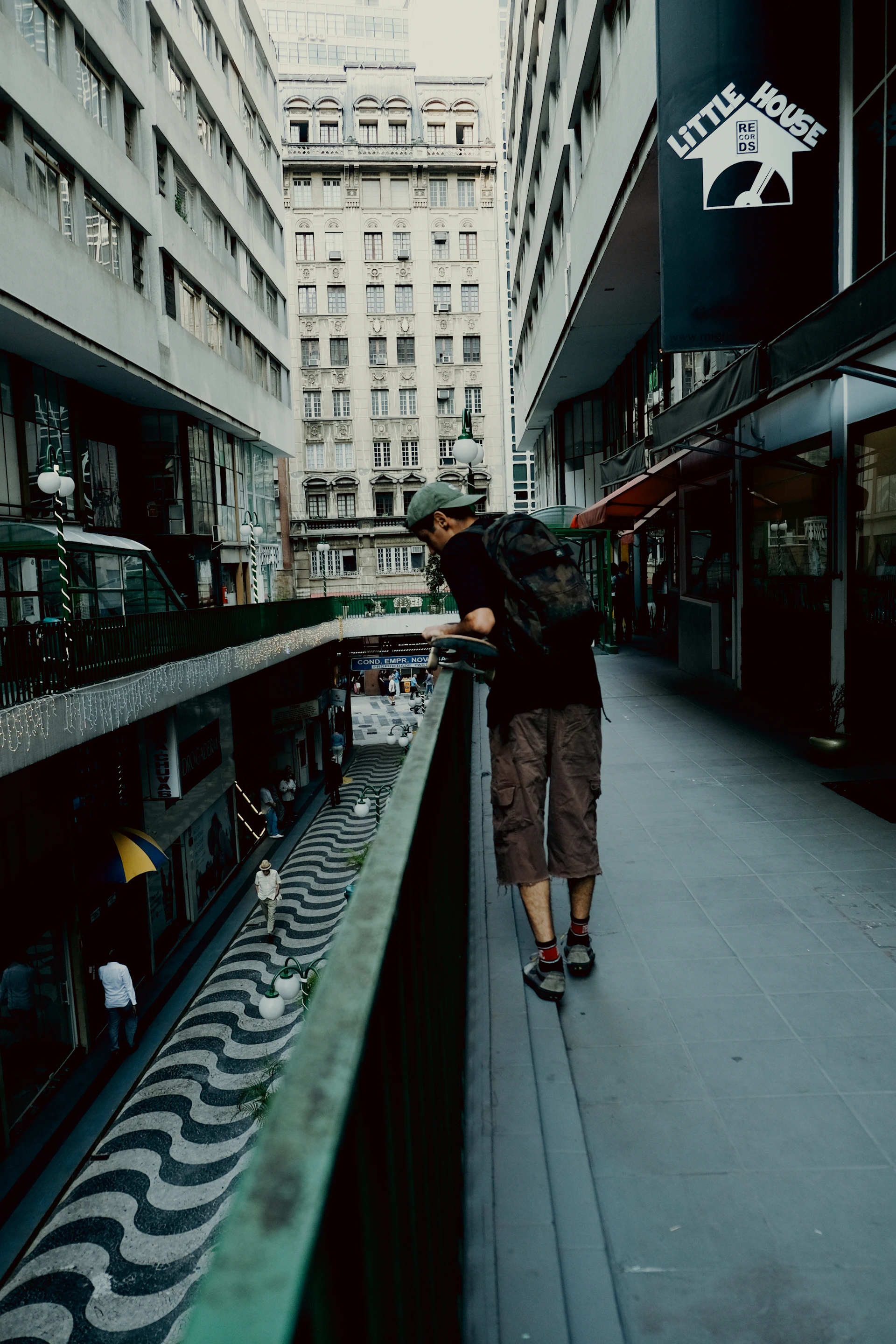 A man walking down a street next to tall buildings