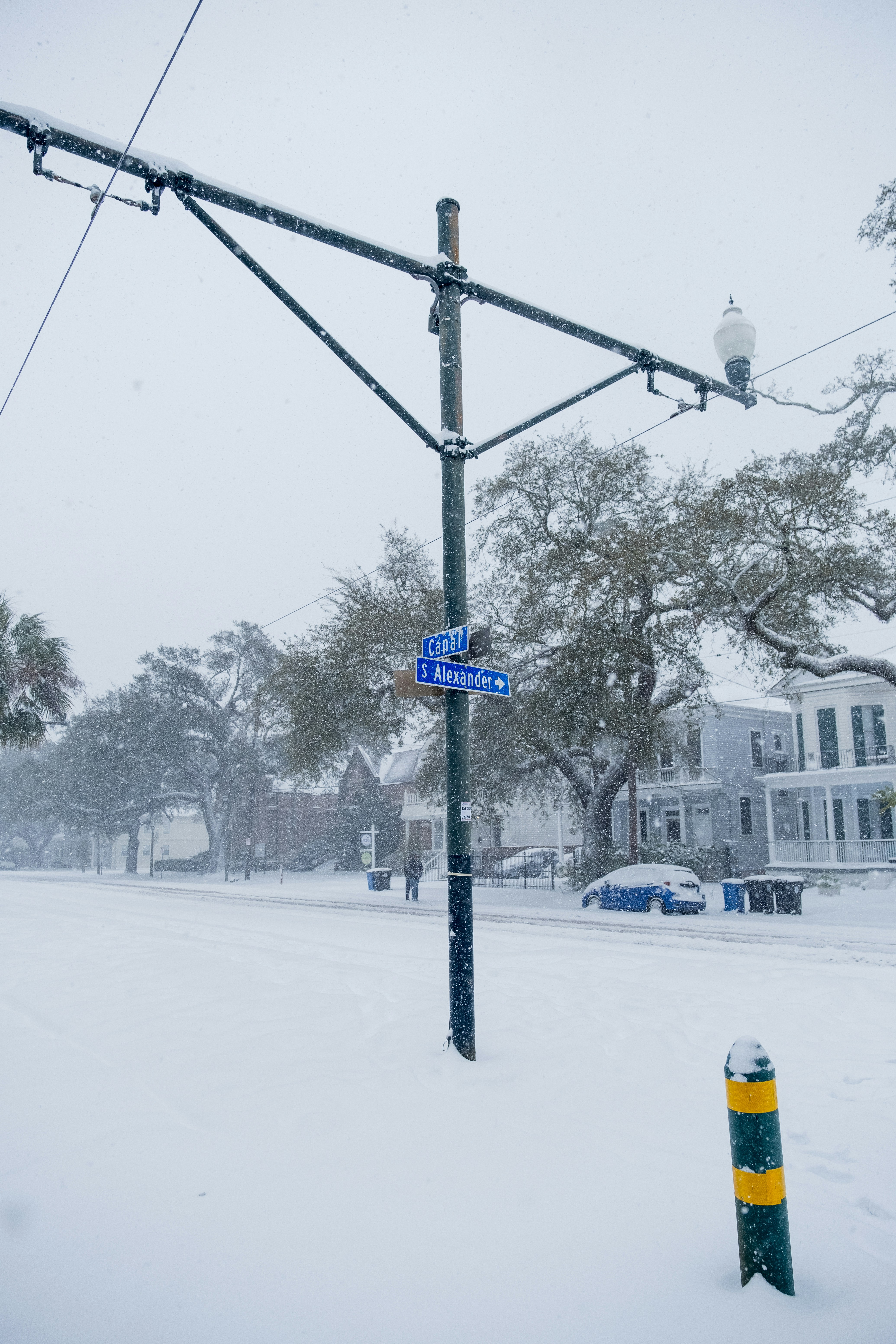 A street sign on a pole in the snow