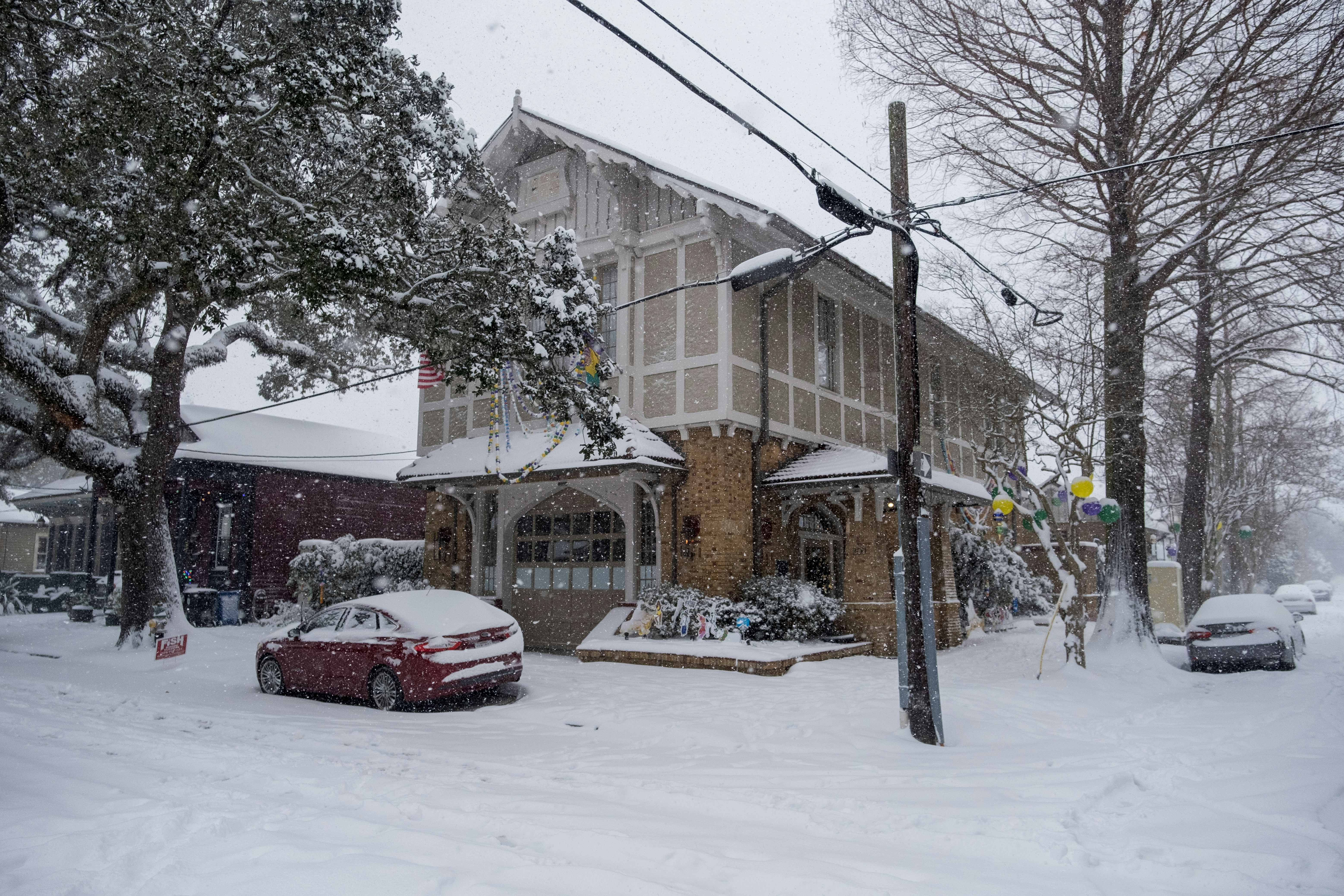 A car parked in front of a building covered in snow