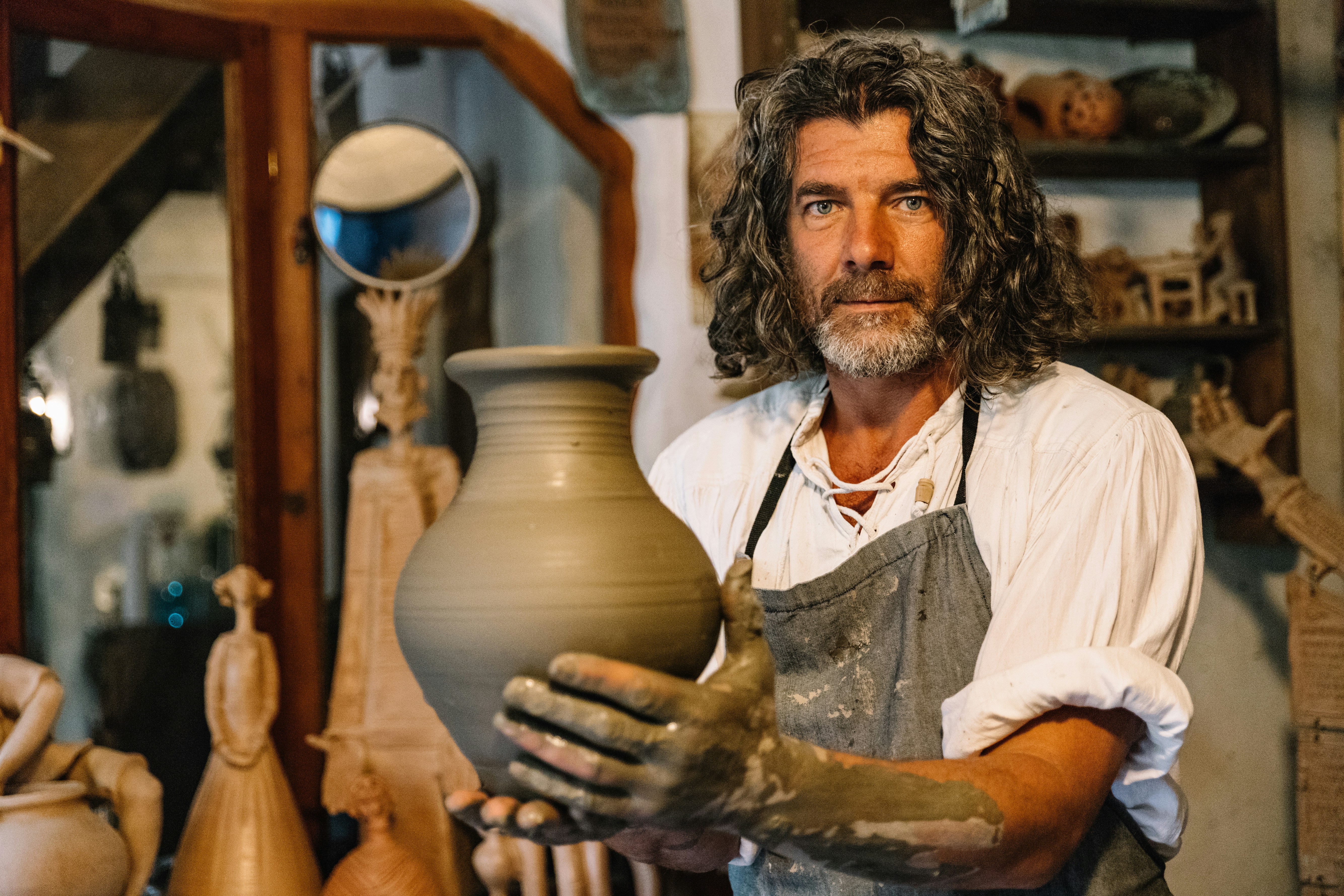 Portrait of a romanian clay artist, holding his creation