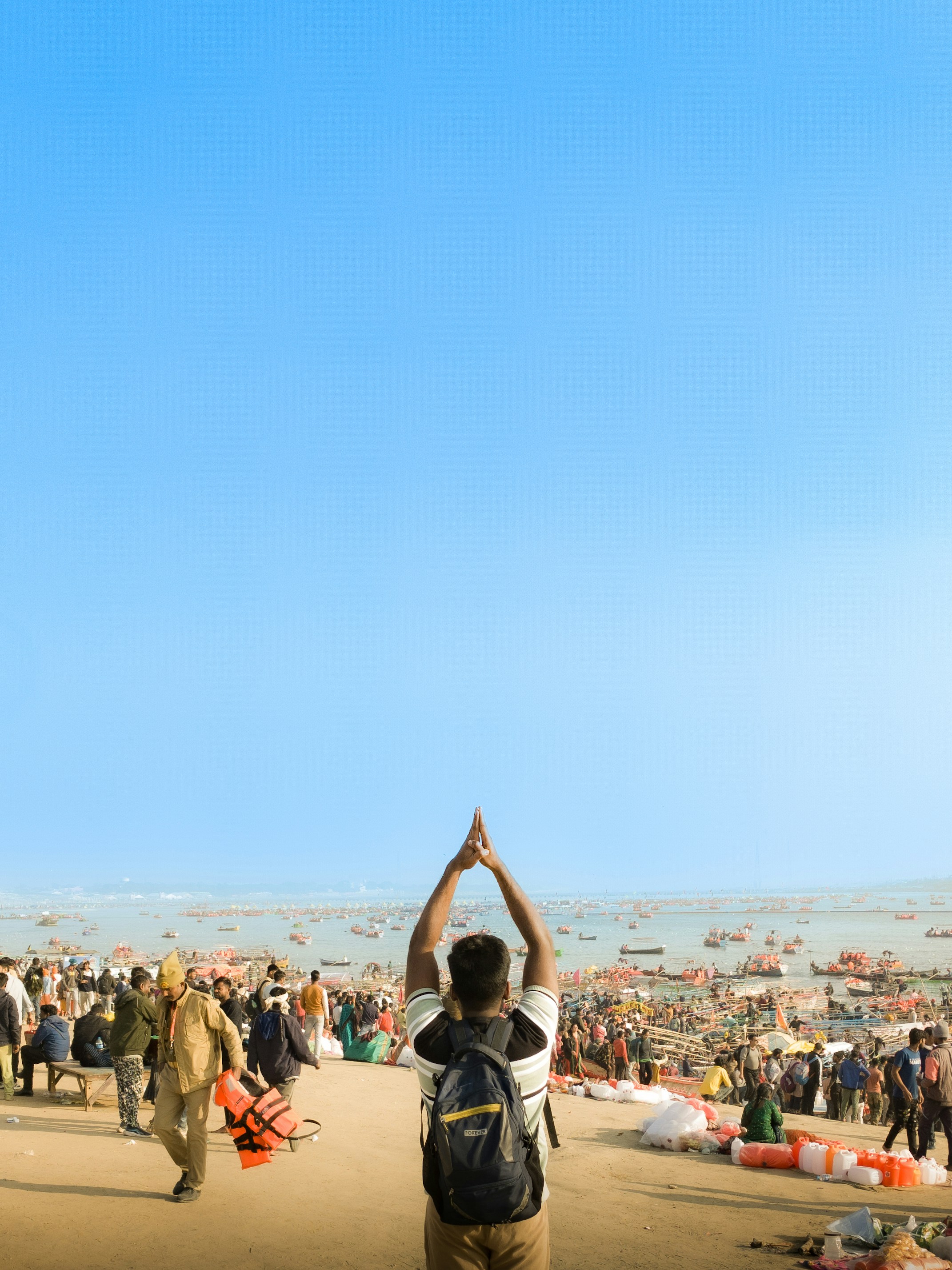 A group of people standing on top of a sandy beach photo – Free Blue ...