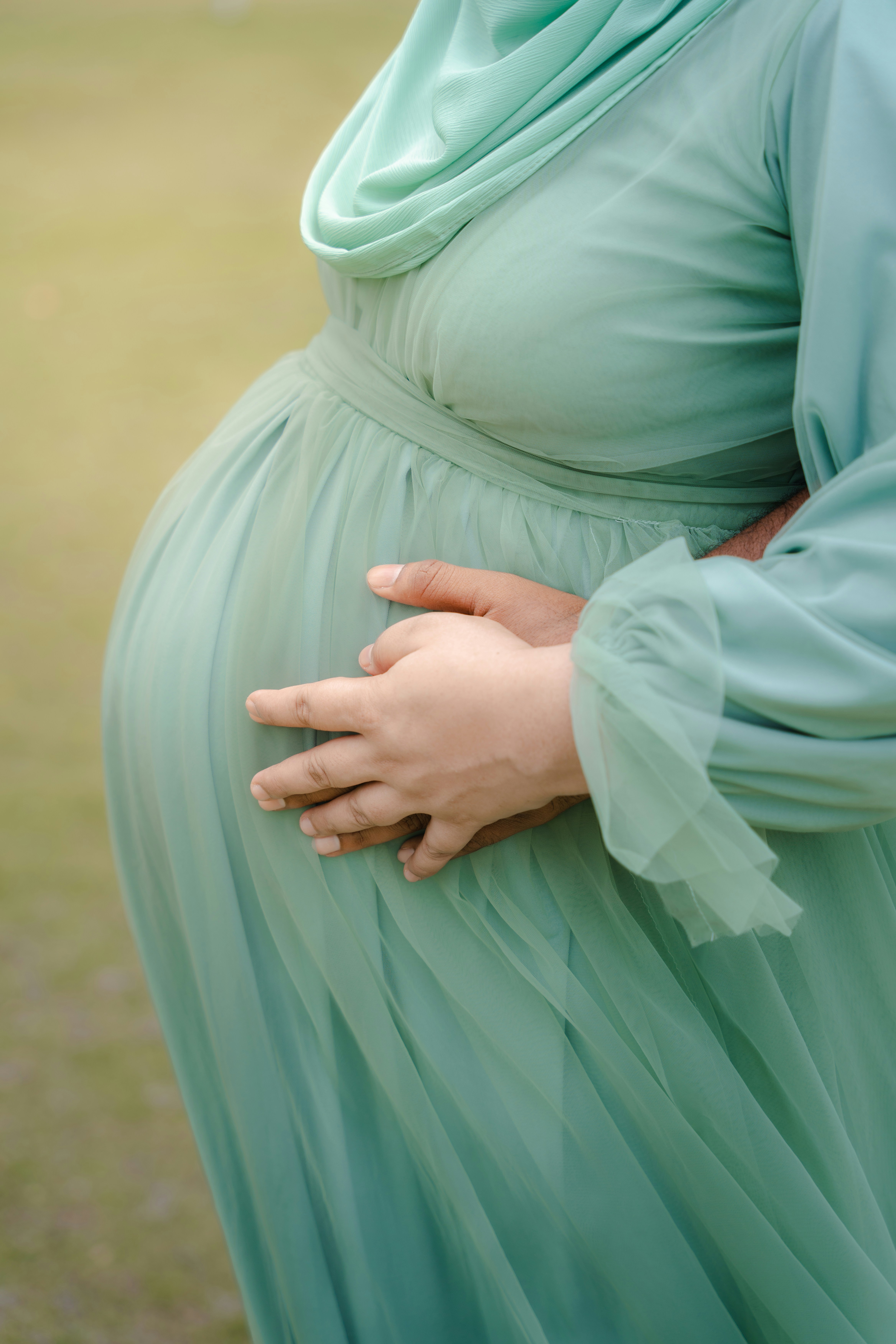 A pregnant woman in a green dress standing in a field photo – Free ...