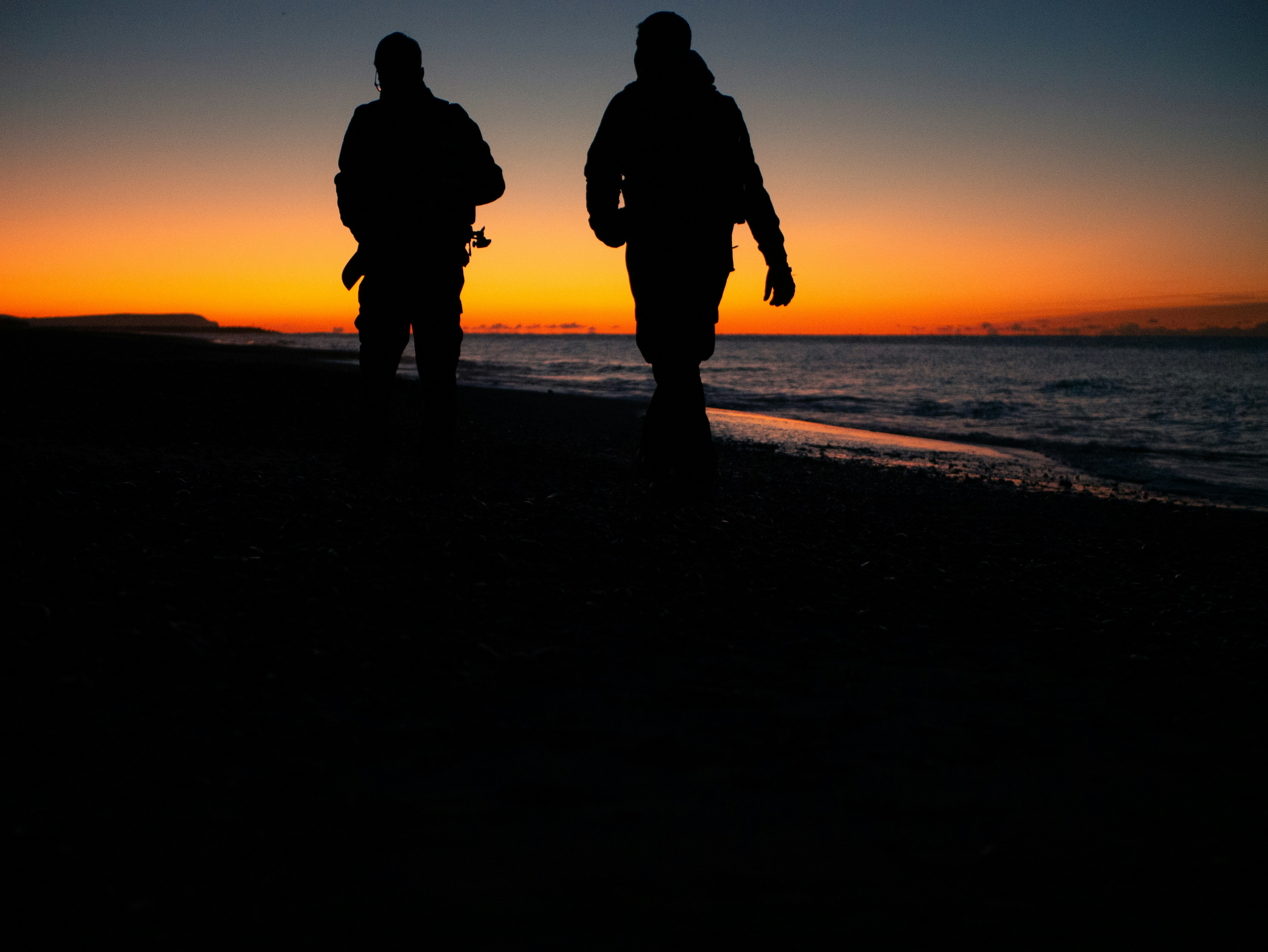 Two people walking on a beach at sunset photo – Free Beach Image on Unsplash, image size:3000x2253