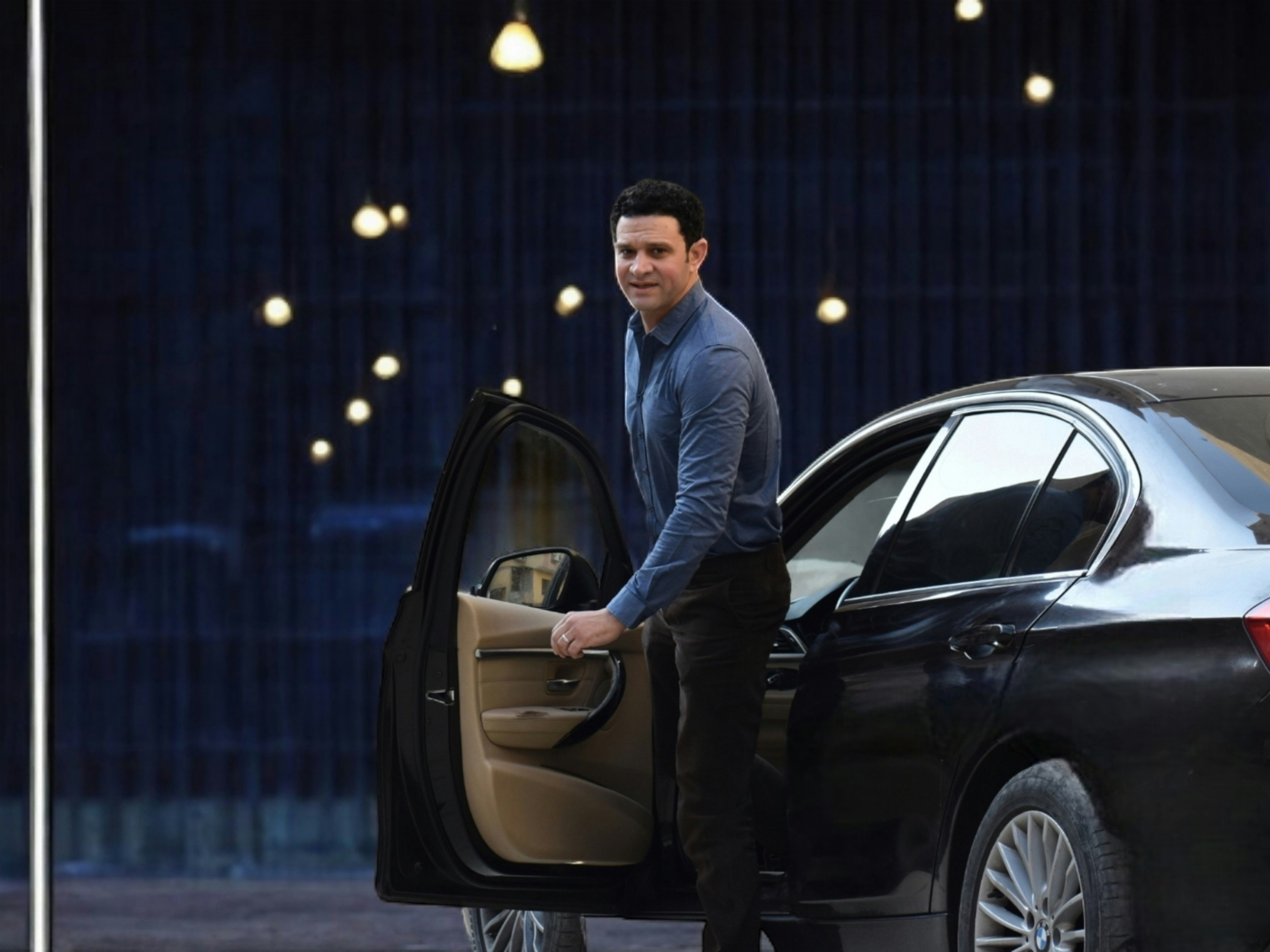 professional chauffeur opening door for executive passenger - executive taxis near me