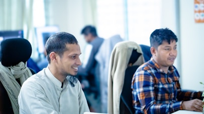 A group of men sitting at a table working on laptops