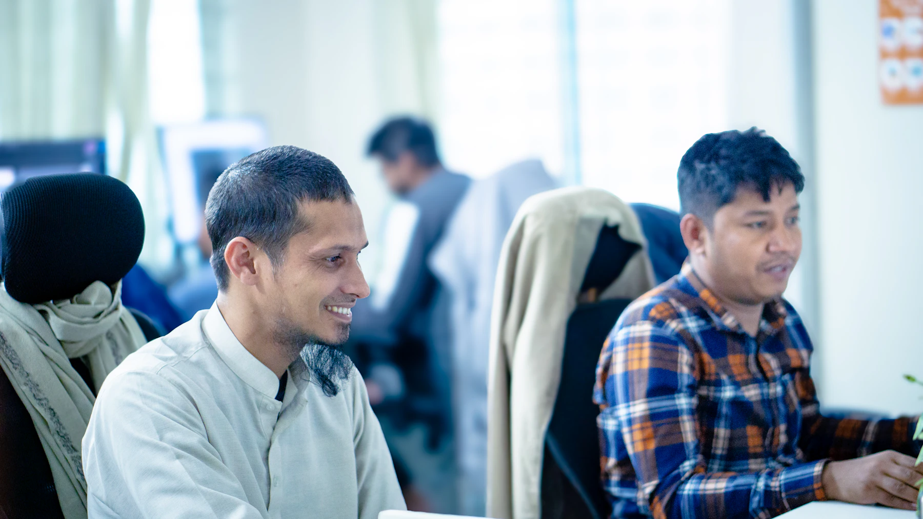 Indian developers smiling while working together at their desks
