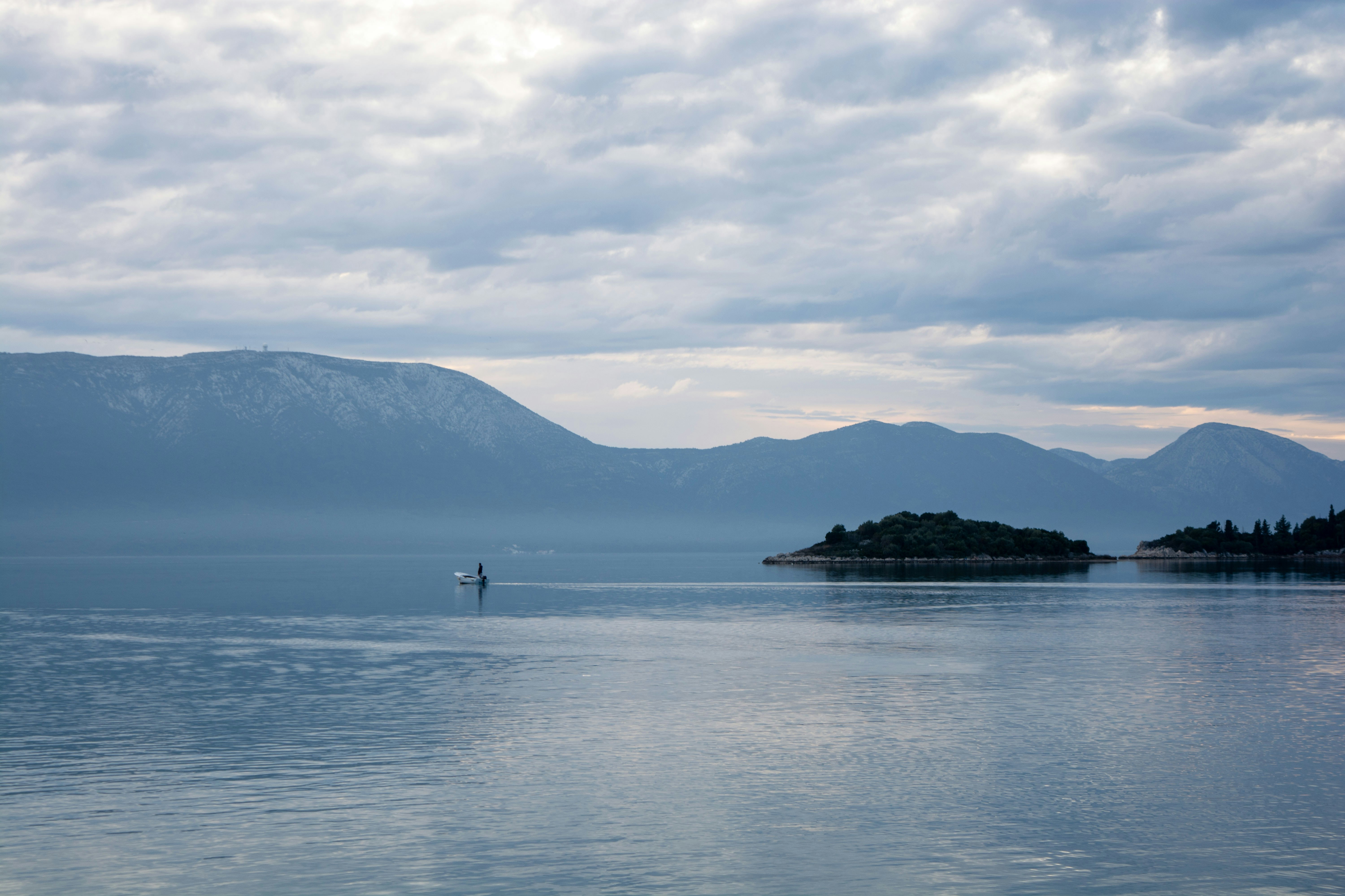 A body of water with mountains in the background