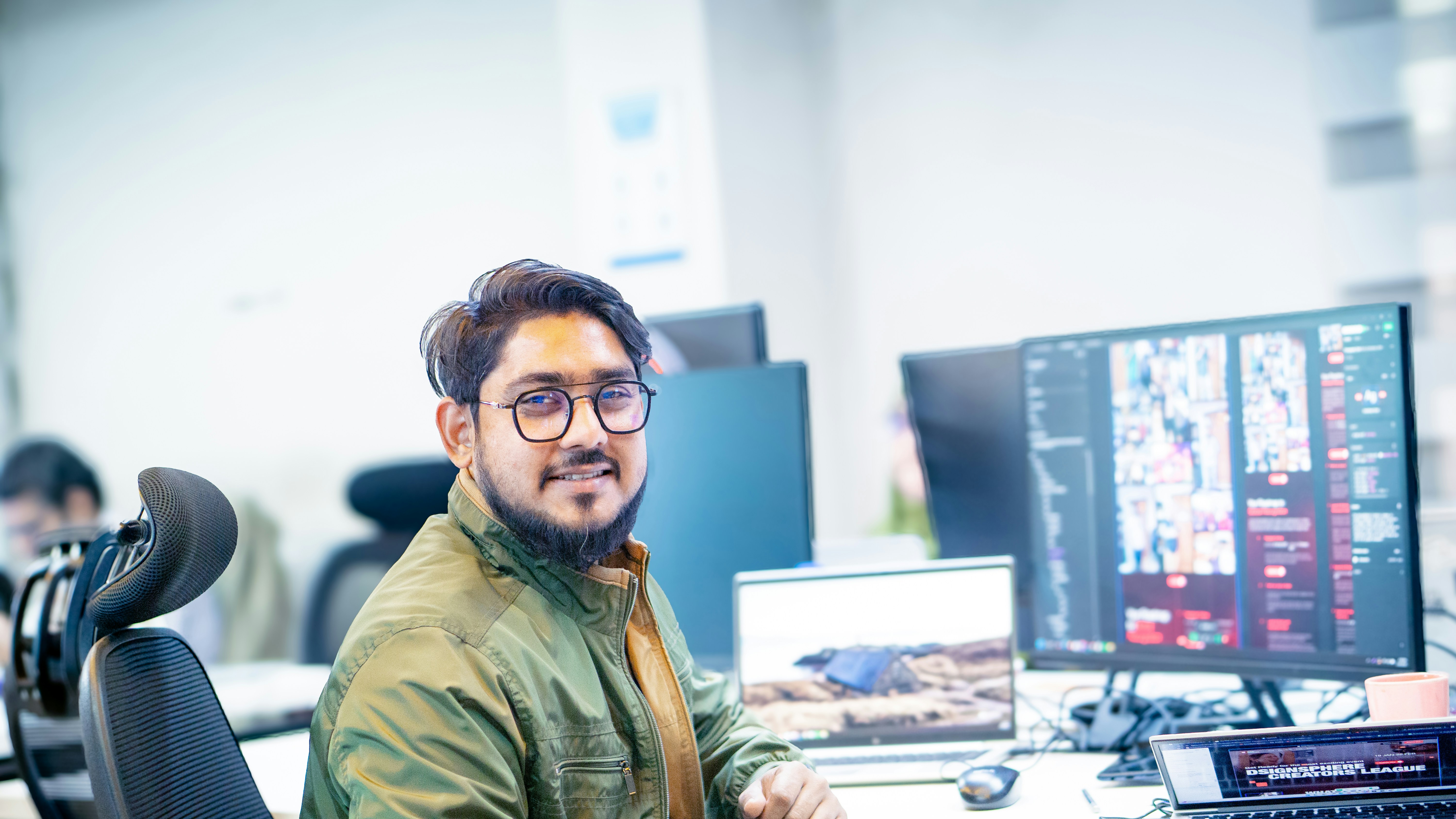 software engineer reviewing code on dual monitors in startup workspace