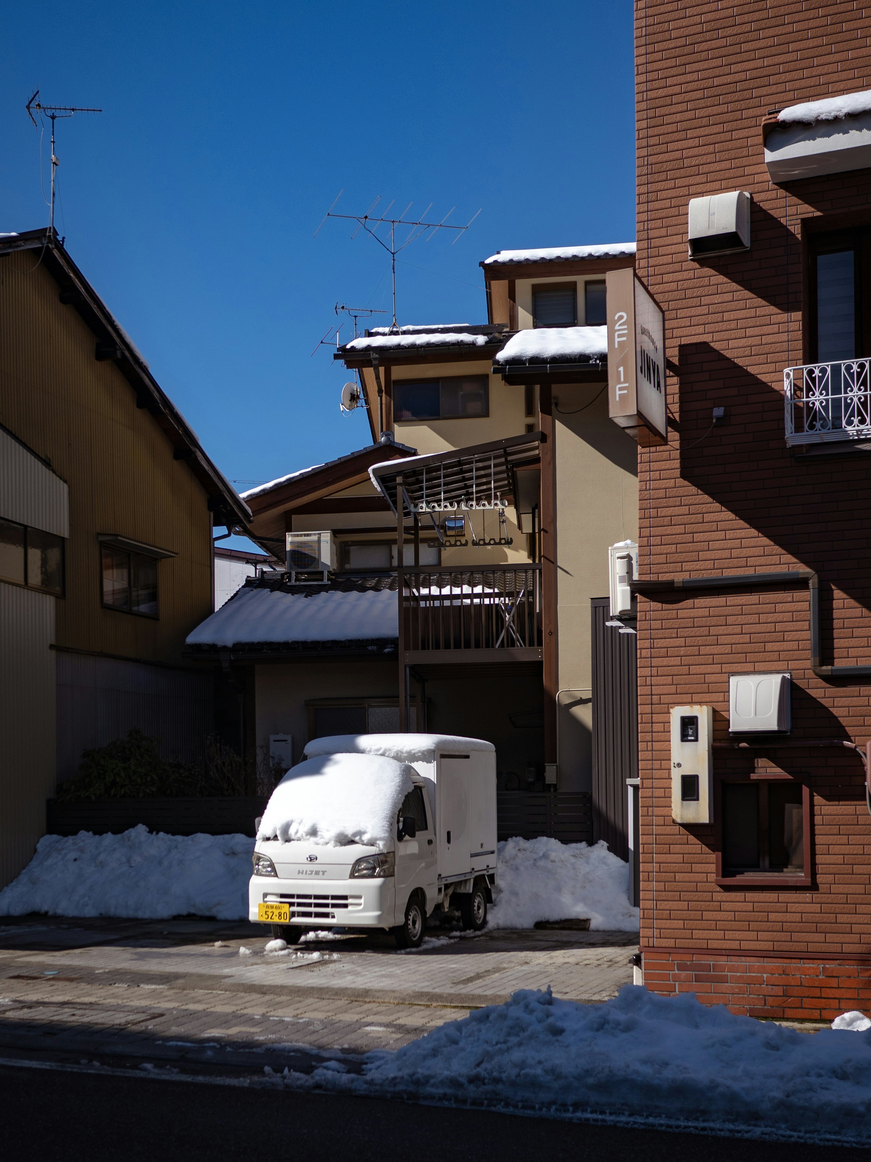A white truck parked in front of a red brick building