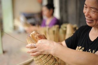 A woman smiles as she holds a bamboo basket