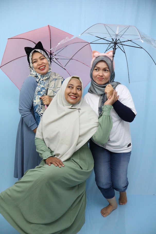 A group of women standing next to each other holding umbrellas