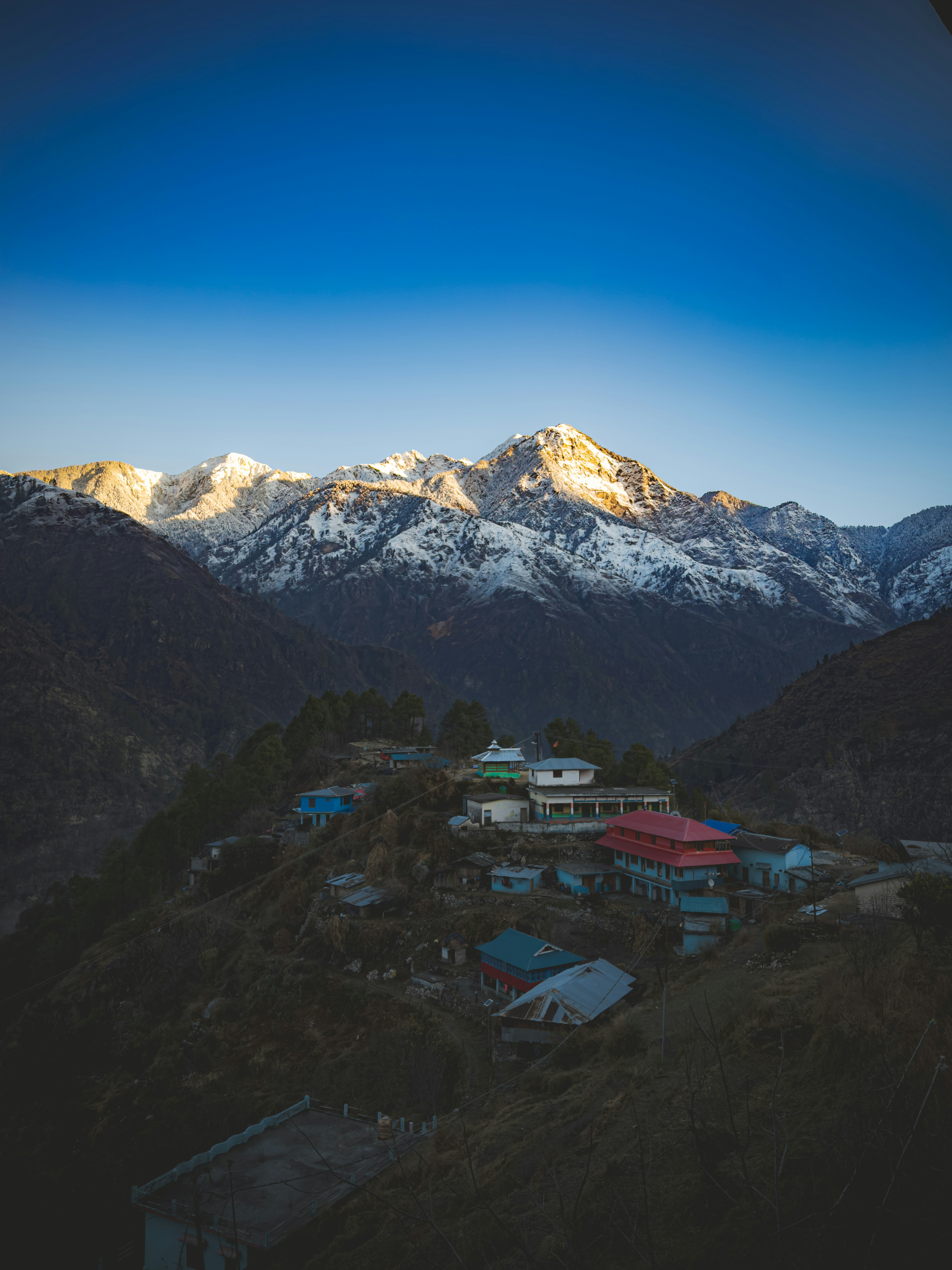A view of a mountain range with houses in the foreground