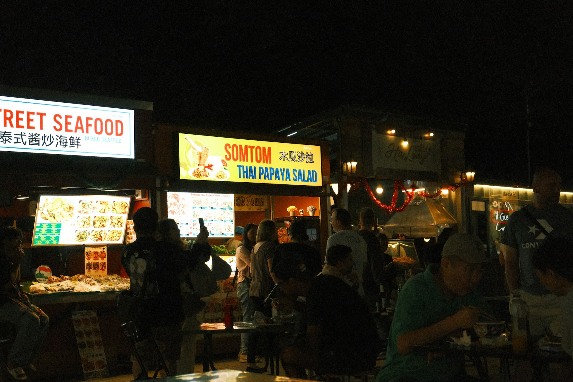 A group of people standing around a food stand