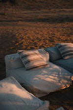 A white couch sitting on top of a sandy beach