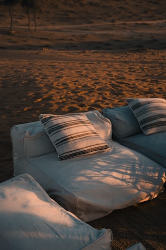 A white couch sitting on top of a sandy beach
