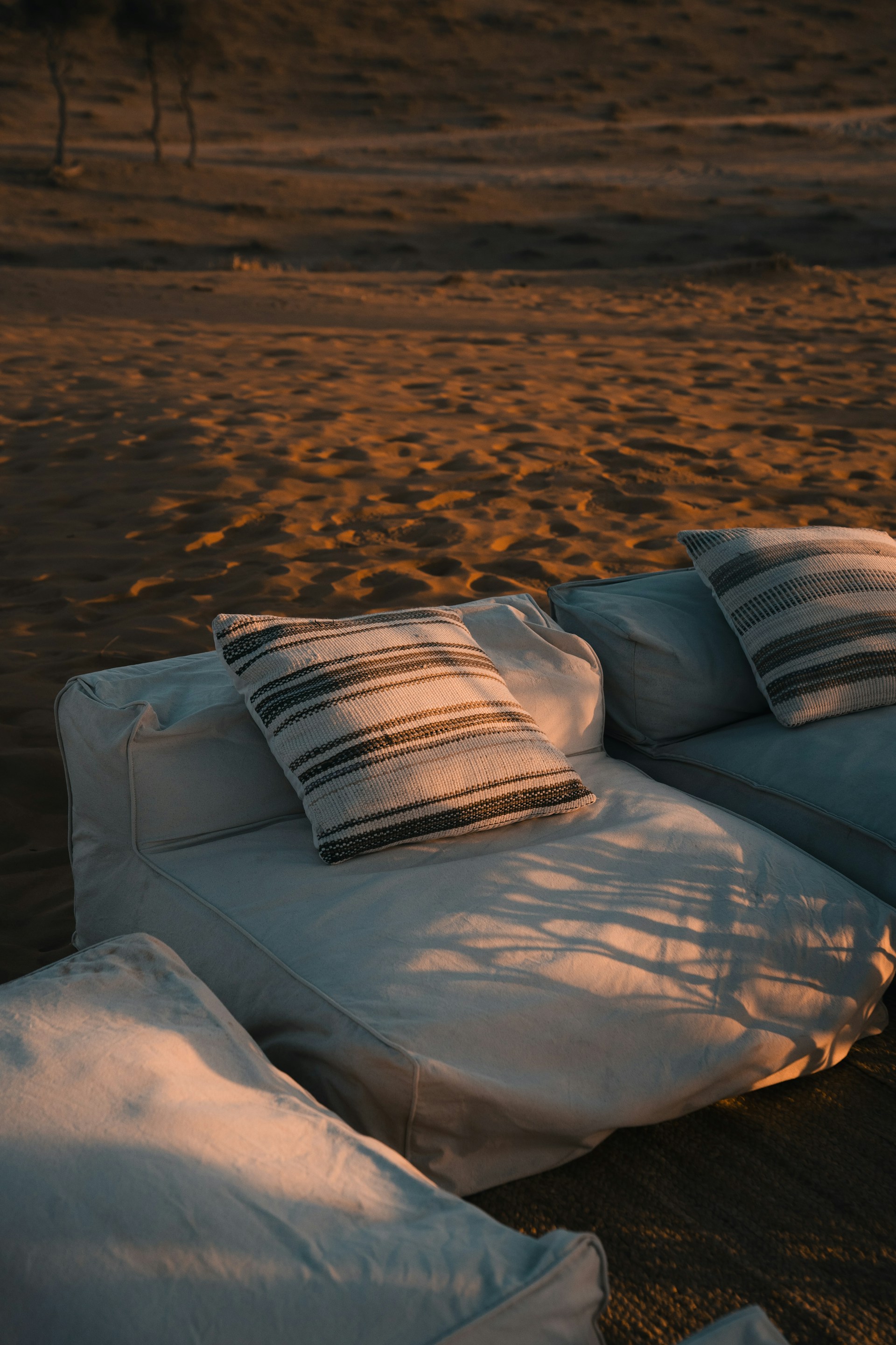 A white couch sitting on top of a sandy beach