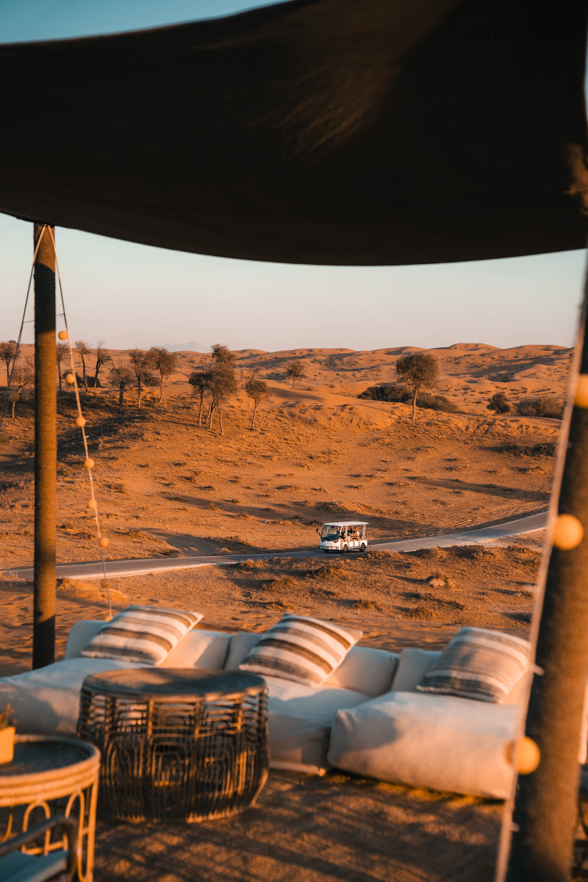 A desert setting with couches and low tables arranged on the sand